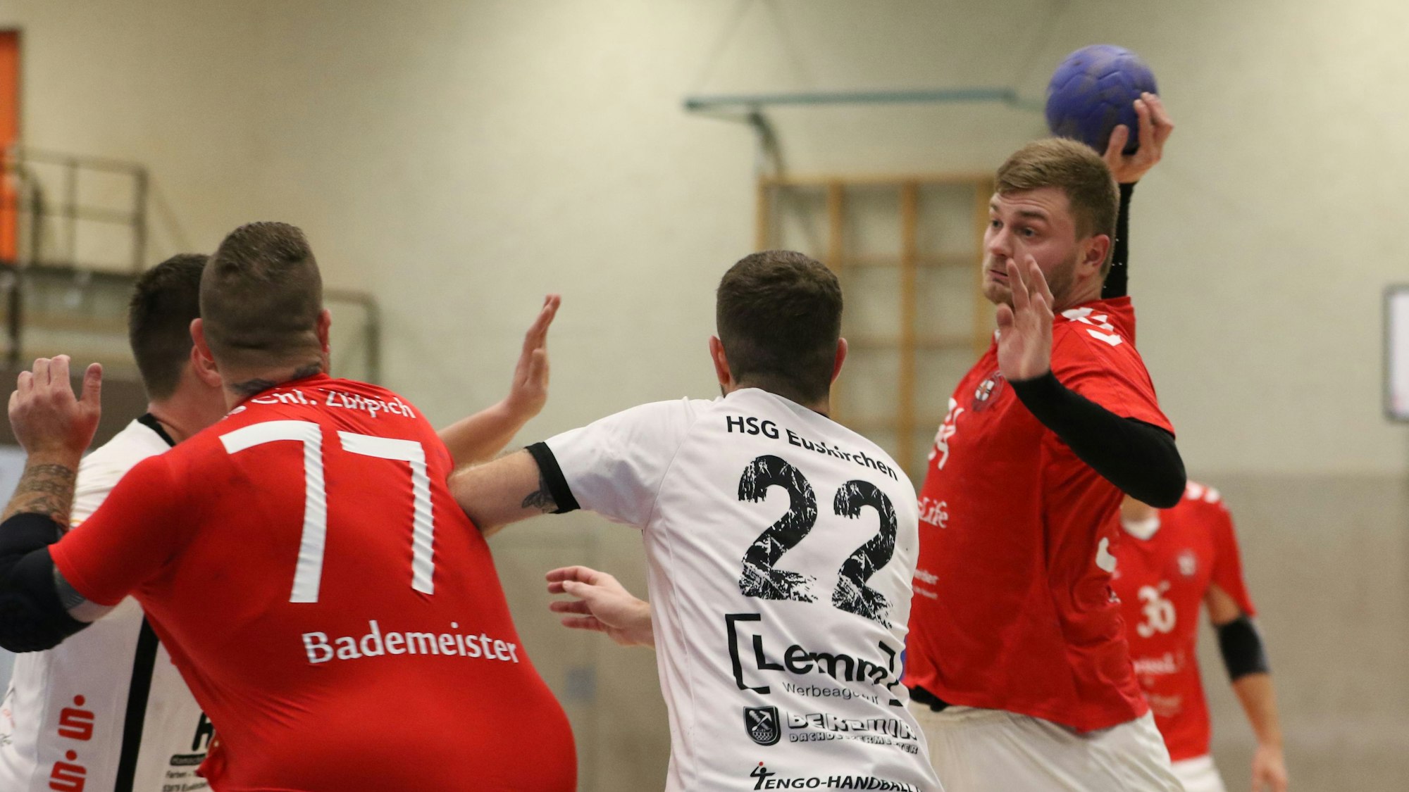 Ein Handballer wirft auf das Tor, vor ihm zwei Abwehrspieler.