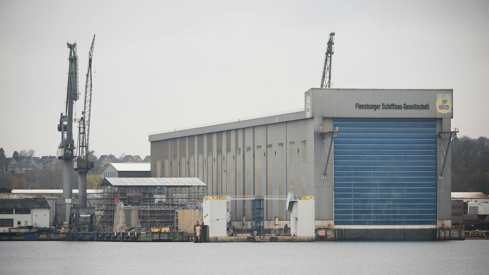 Eine Außenansicht zeigt das Firmengelände und eine Montagehalle der Flensburger Schiffbau-Gesellschaft (FSG).
