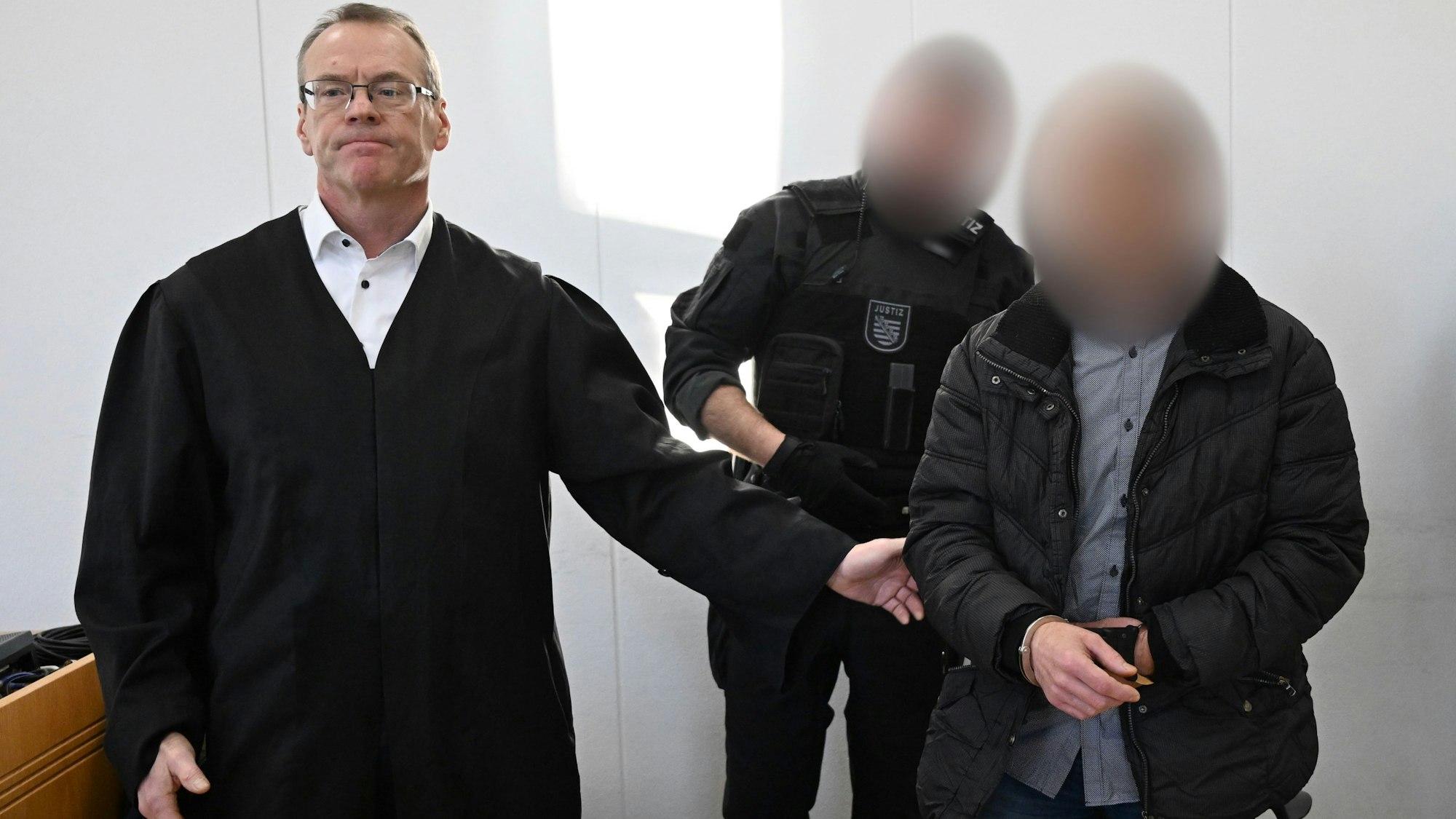 ARCHIV - 17.01.2025, Sachsen, Chemnitz: Der wegen Mordes an der neunjährigen Valeriia Verurteilte wird im Landgericht von einem Justizbeamten neben seinem Verteidiger Jörg Neuber (l) vorgeführt.