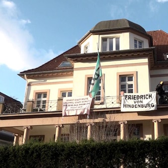 31.01.2025, Niedersachsen, Hannover: Aktivisten sind auf den Balkon der Geschäftsstelle des CDU-Kreisverbands Hannover geklettert und haben dort Transparente mit der Aufschrift «Knast statt Hilfe, Knüppel statt Schutz - ihr seid das Problem, nicht der «Flüchtlingsfluss»» und «Friedrich von Hindenburg» befestigt.