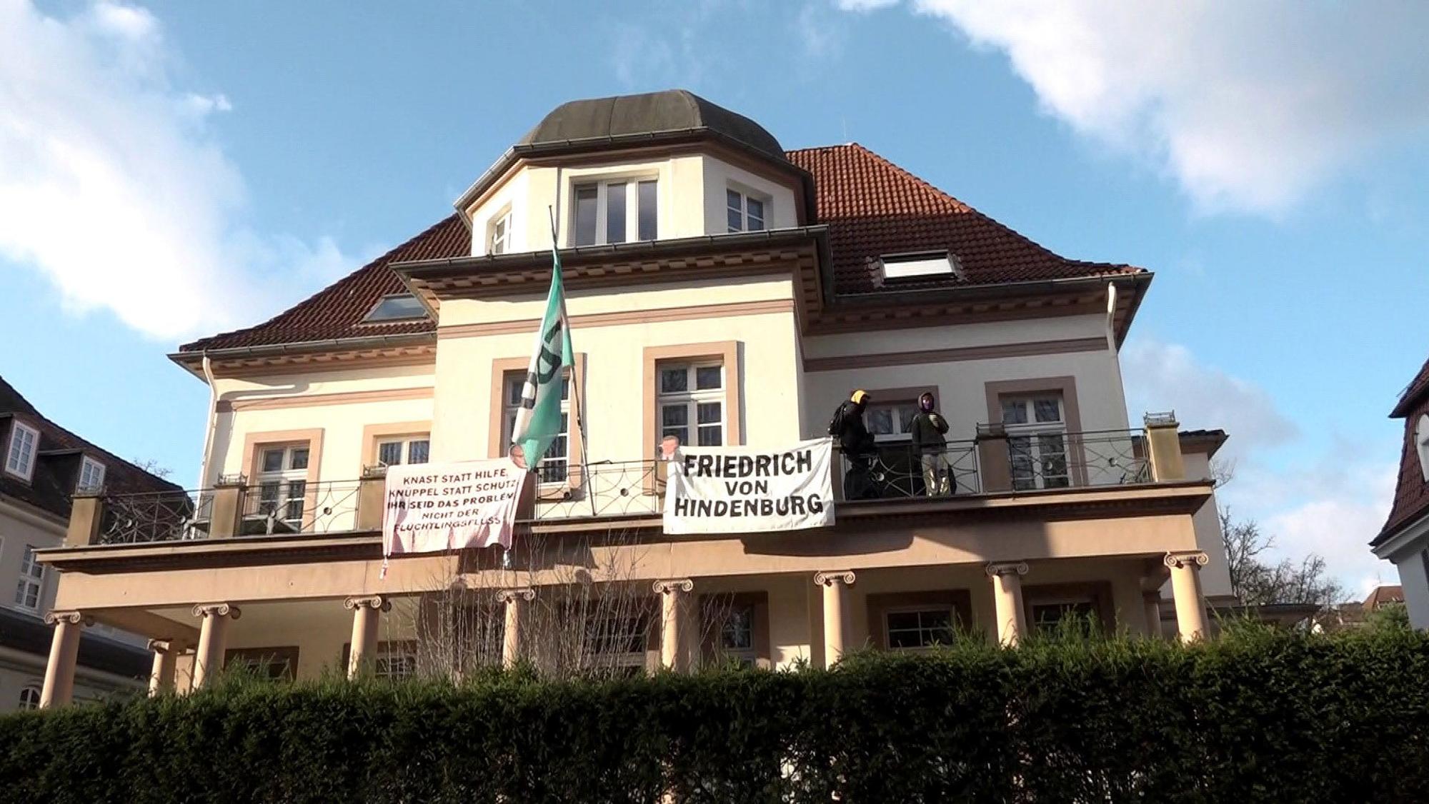 31.01.2025, Niedersachsen, Hannover: Aktivisten sind auf den Balkon der Geschäftsstelle des CDU-Kreisverbands Hannover geklettert und haben dort Transparente mit der Aufschrift «Knast statt Hilfe, Knüppel statt Schutz - ihr seid das Problem, nicht der «Flüchtlingsfluss»» und «Friedrich von Hindenburg» befestigt.