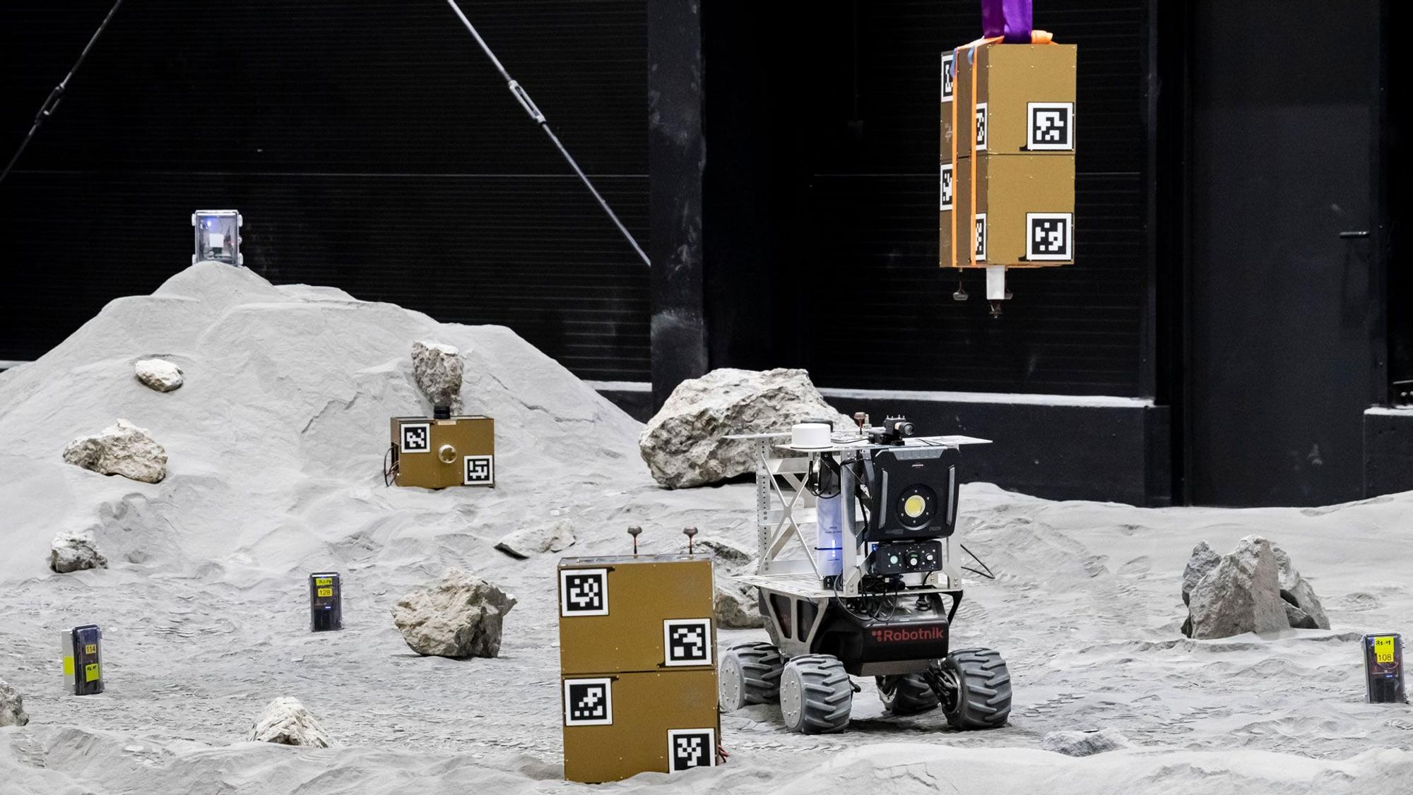 Das DLR-Institut für Kommunikation und Navigation hat in der LUNA-Halle ein Experiment durchgeführt, bei dem sich Nutzlast-Boxen, Sensoren und Rover zu einem Schwarmnavigationsnetzwerk verbinden.