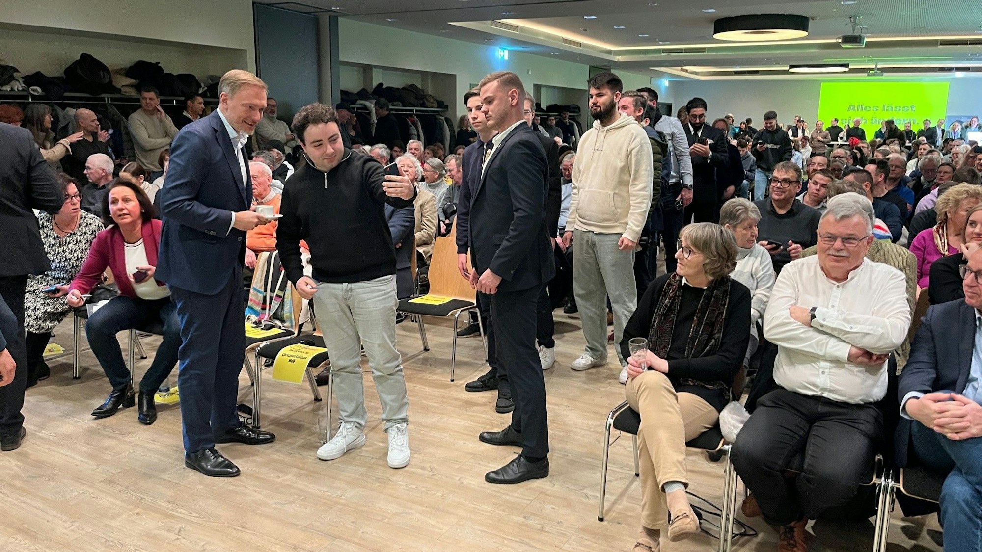 Viele junge Leute stehen in einer Schlange vor Christian Lindner.