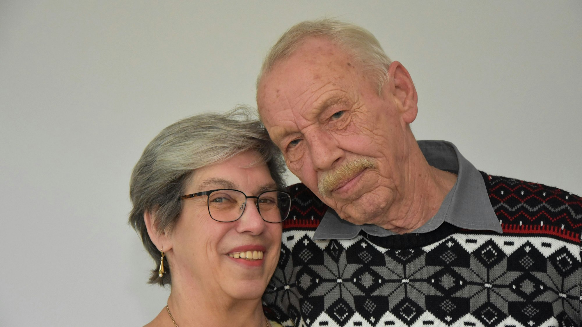 Das Ehepaar schaut in die Kamera, sie lächelt.