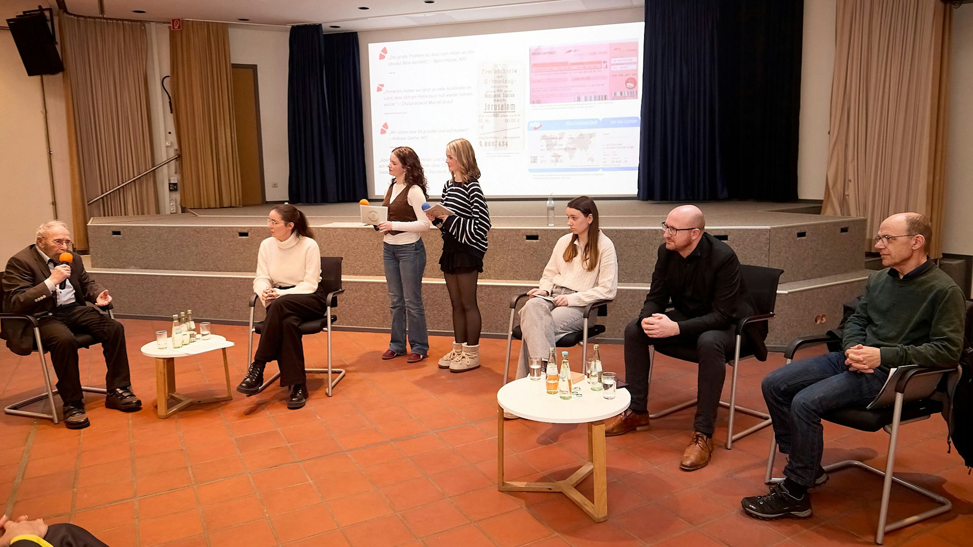 Die Gesprächsteilnehmer sitzen an Tischen. Marja Hölz und Clara Gehlen moderierten die Veranstaltung stehend.