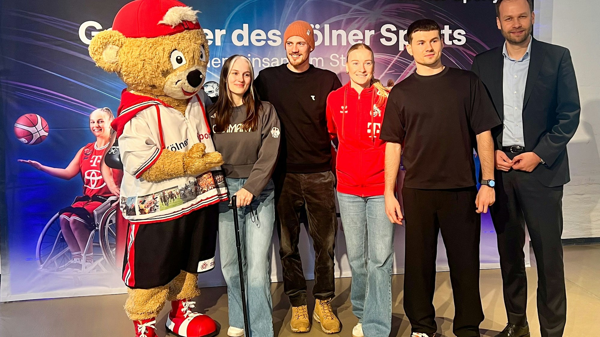 Rollstuhlbasketball-Spielerin Lisa Bergenthal, Langstreckenläufer Jonathan Dahlke, FC-Fußballerin Anna Gerhardt und Breaker Mario Eckel sind Teil der Kampagne „Gesichter des Kölner Sports“ (v. l. n. r.). Sportdezernent Robert Voigtsberger (rechts außen) gratuliert ihnen.