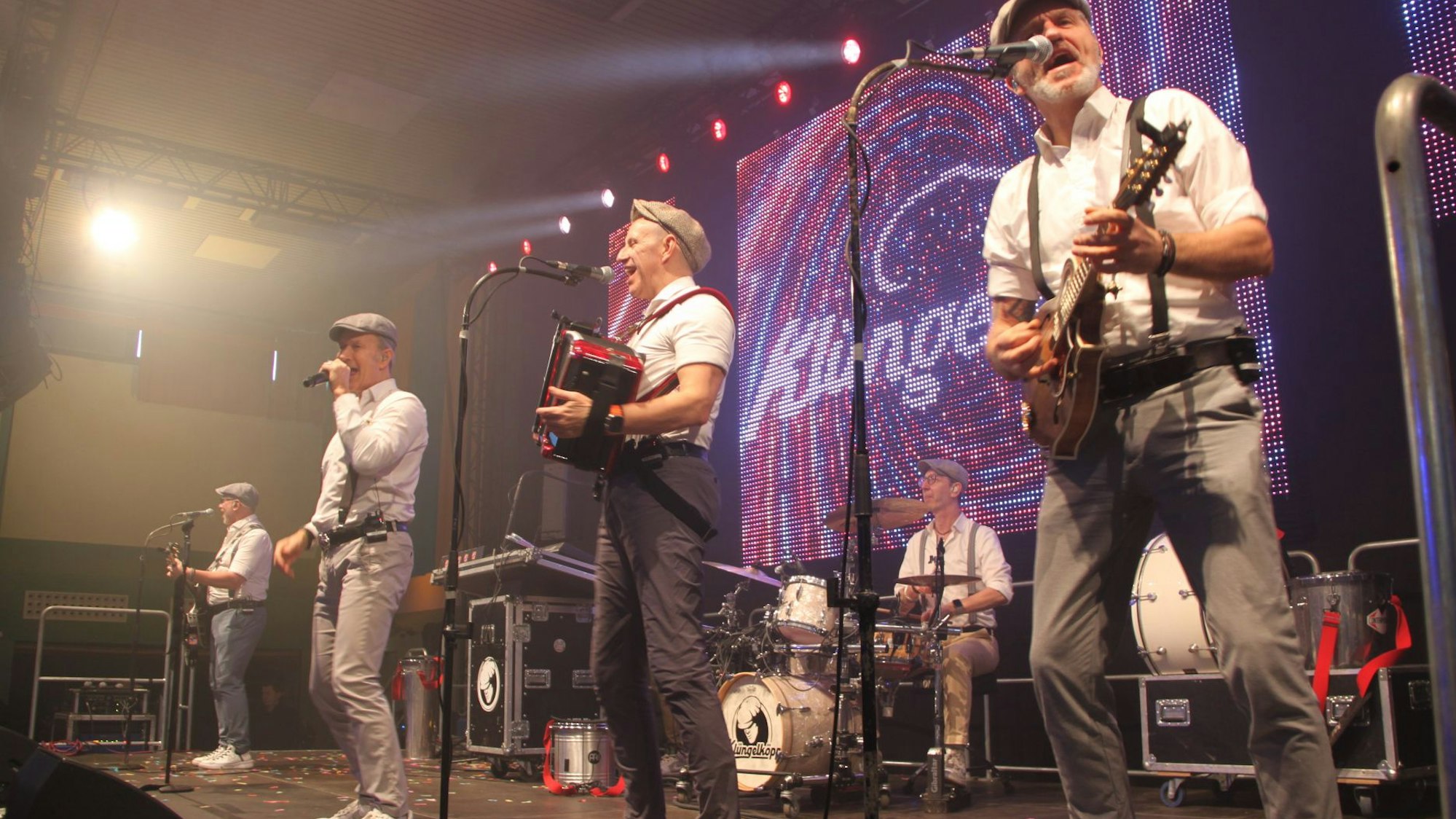 Die fünf Musiker spielen auf der Bühne in Mechernich - wie gewohnt mit ihren Markenzeichen Kappe und Hosenträger.