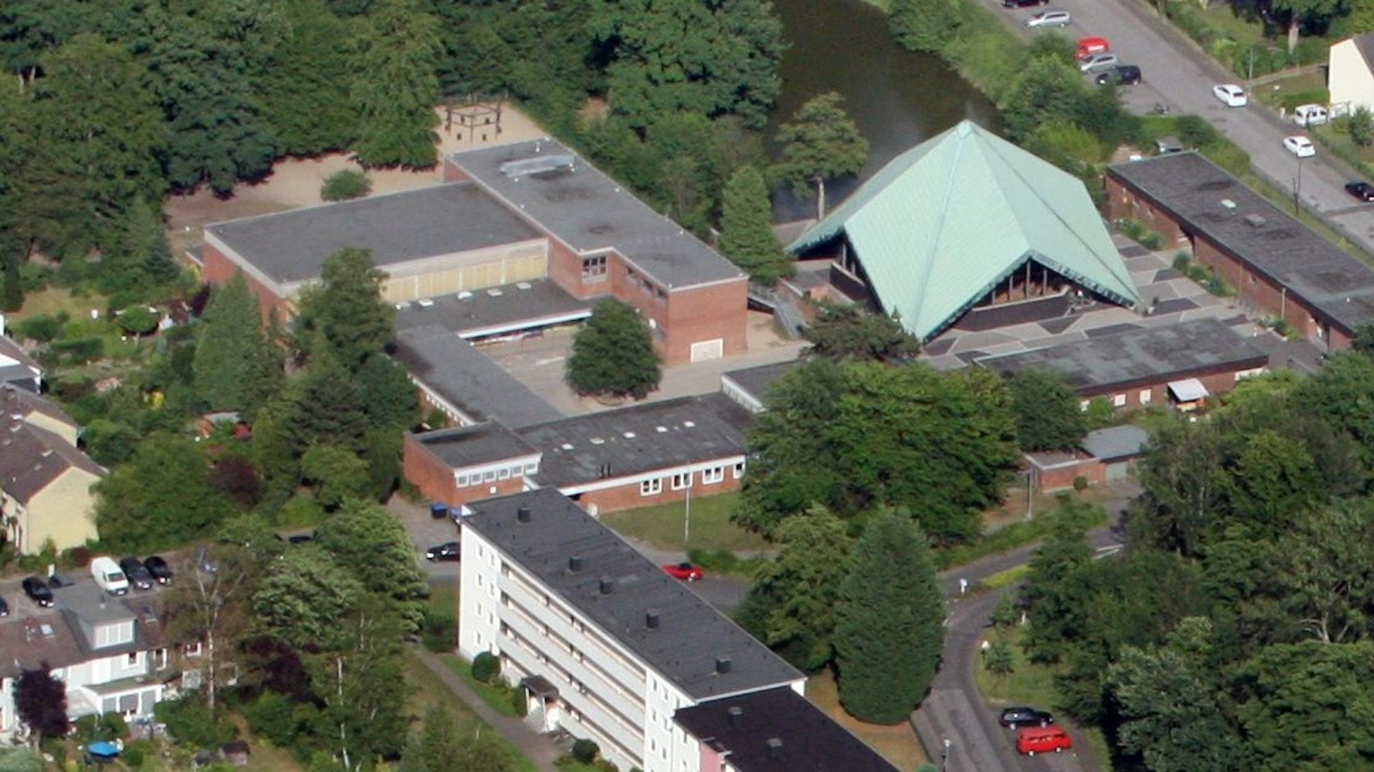 Auf einem Luftbild sind Häuser, die Zeltkirche und die Grundschule von Bergisch Gladbach-Kippekausen zu sehen.