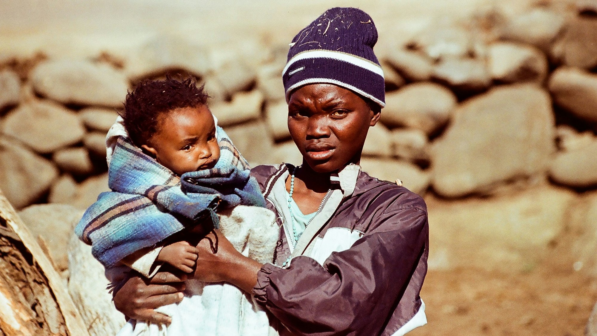 Eine afrikanische Frau mit Kind auf dem Arm.