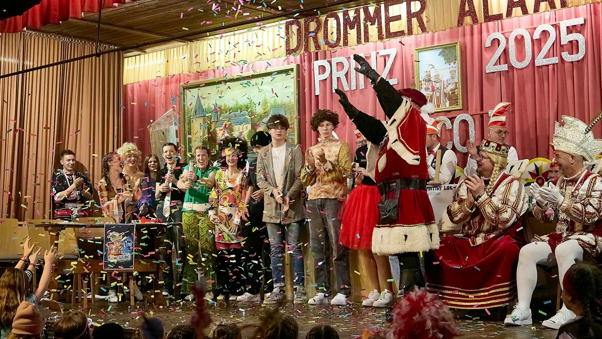 Mehrere Karnevalisten stehen auf der Bühne in Schleiden-Dreiborn. Es regnet bunte Konfetti-Schnipsel.