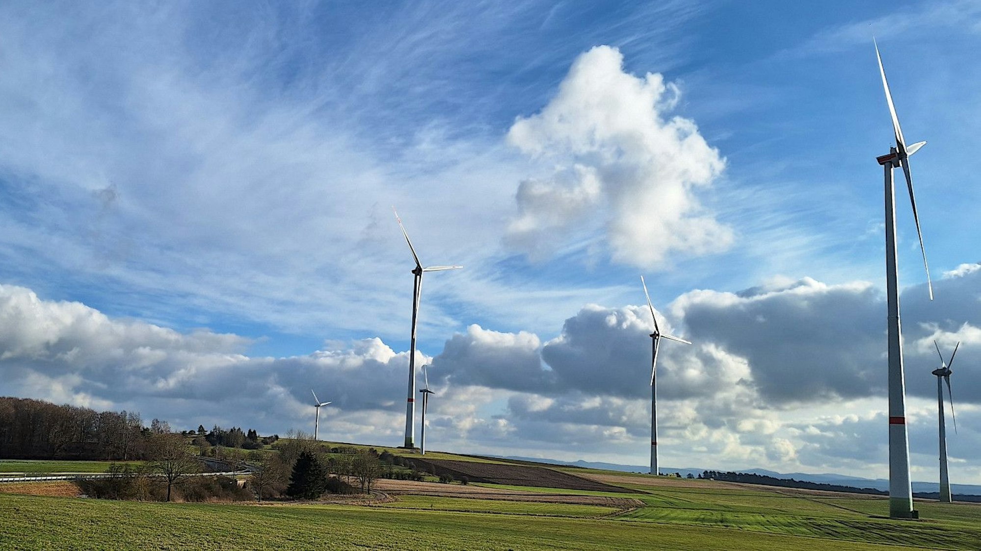 Sechs Windkraftanlagen stehen auf einer Wiese bei Blankenheim.
