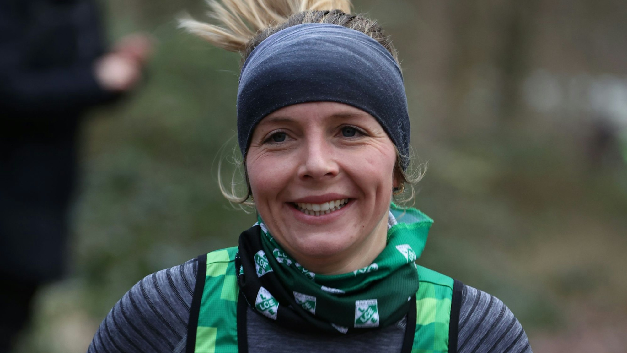 Läuferin Nora Schmitz vom LC Euskirchen trägt ein Stirnband und lächelt beim Laufen.