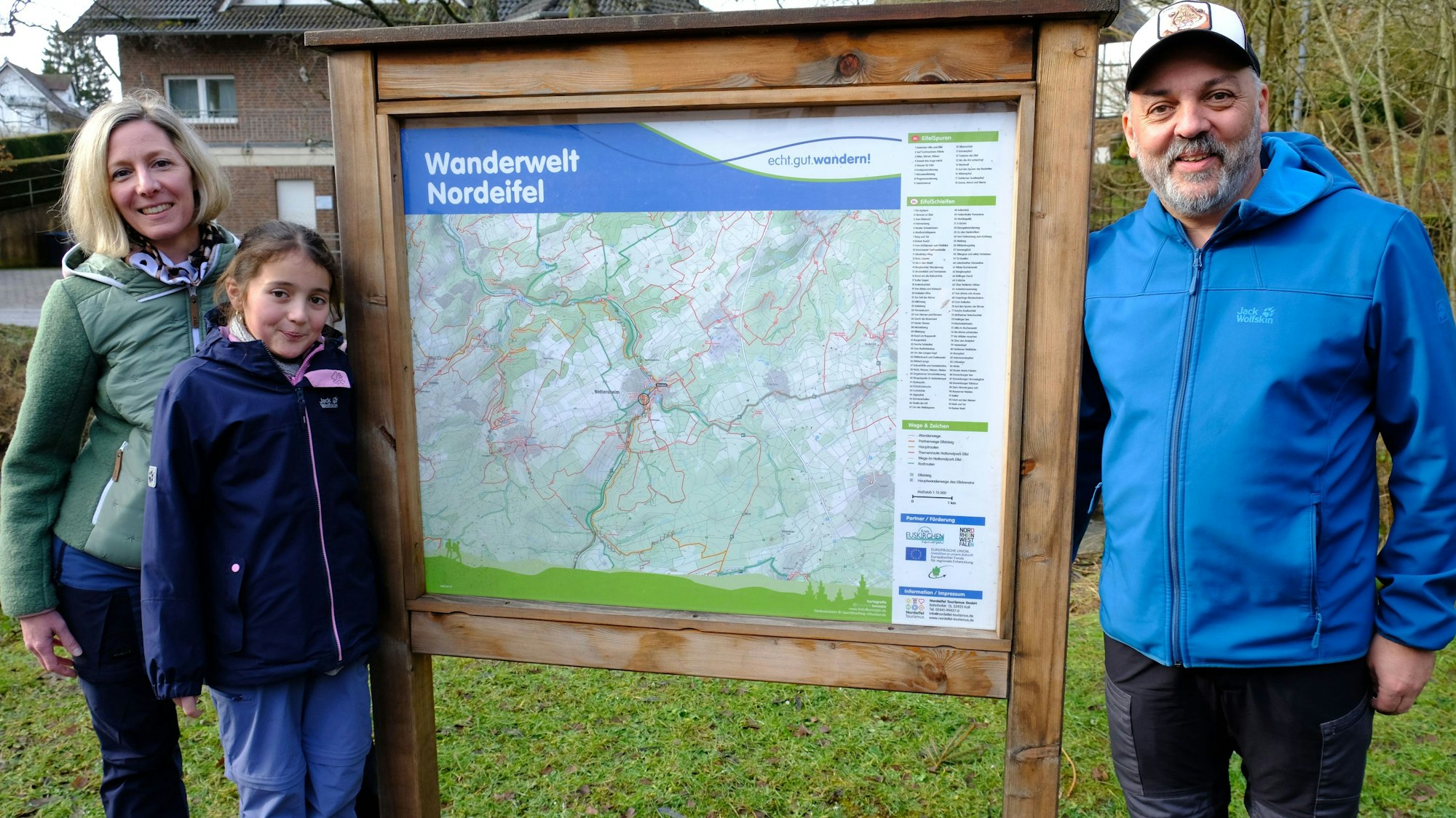 Christina und Thomas Mießeler aus Nettersheim (hier mit Tochter Lina) posieren an einer Wandertafel am Naturzentrum in Nettersheim.