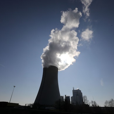 Aus einem Kühlturm von einem Kraftwerk steigt Rauch in den Himmel.