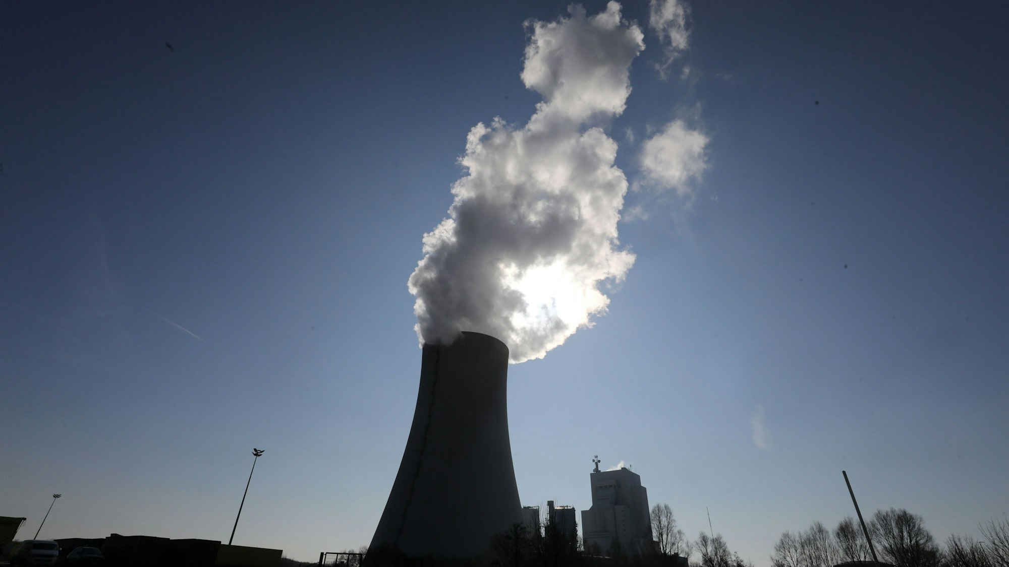 Aus einem Kühlturm von einem Kraftwerk steigt Rauch in den Himmel.