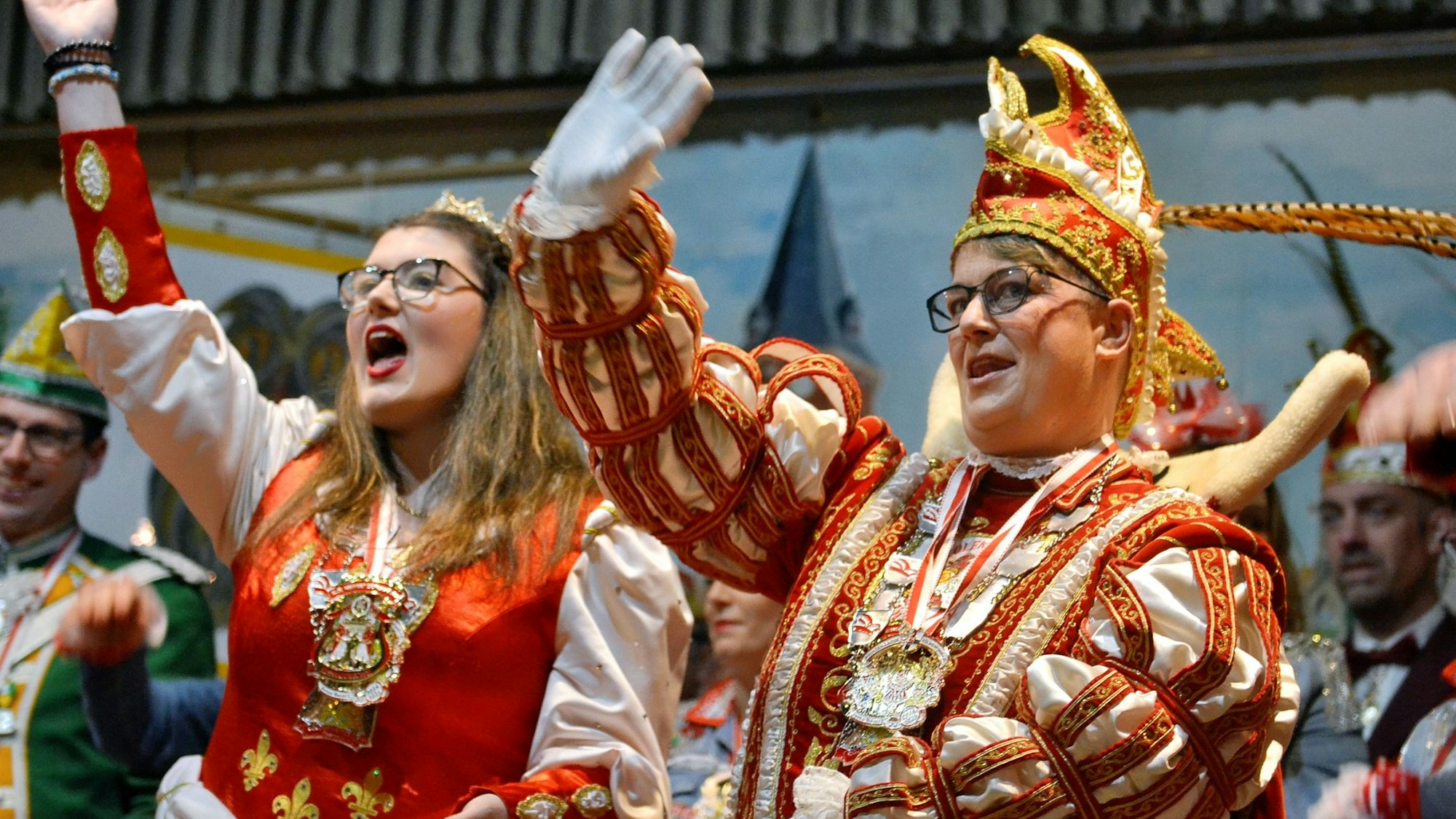 Das Jubiläumsprinzenpaar sind Prinz Melli I. und Prinzessin Leonie. Sie tragen ihren Ornat und winken ins Publikum.
