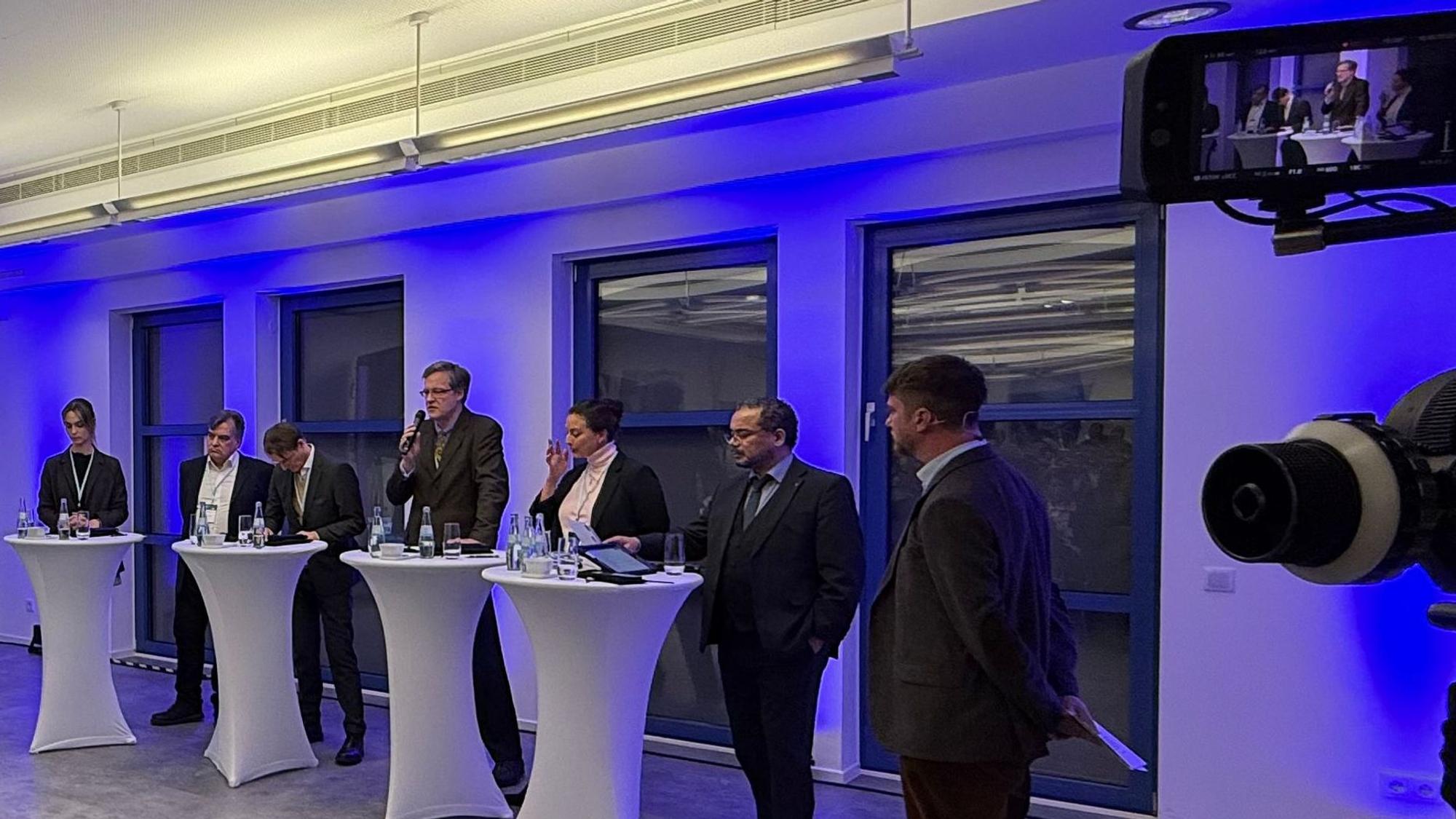 Nyke Slawik, Tomás Santillán, Karl Lauterbach, Rolf Albach, Caroline Bosbach und Harald Weyel stehen an Tischen in der Opladener IHK