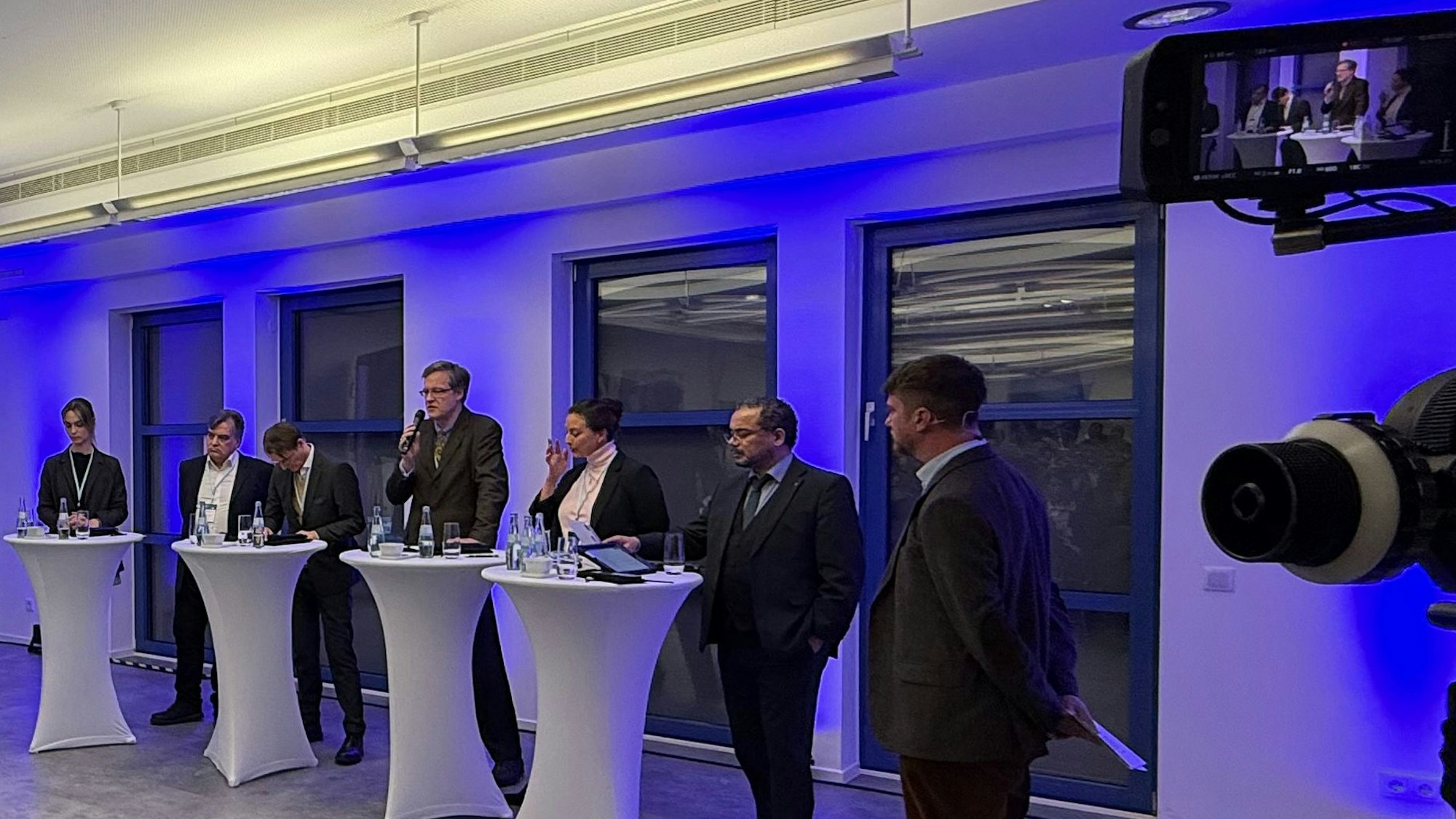 Nyke Slawik, Tomás Santillán, Karl Lauterbach, Rolf Albach, Caroline Bosbach und Harald Weyel stehen an Tischen in der Opladener IHK