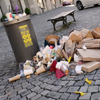 Ein komplett mit Pappbechern und Verpackungen überfüllter Mülleimer