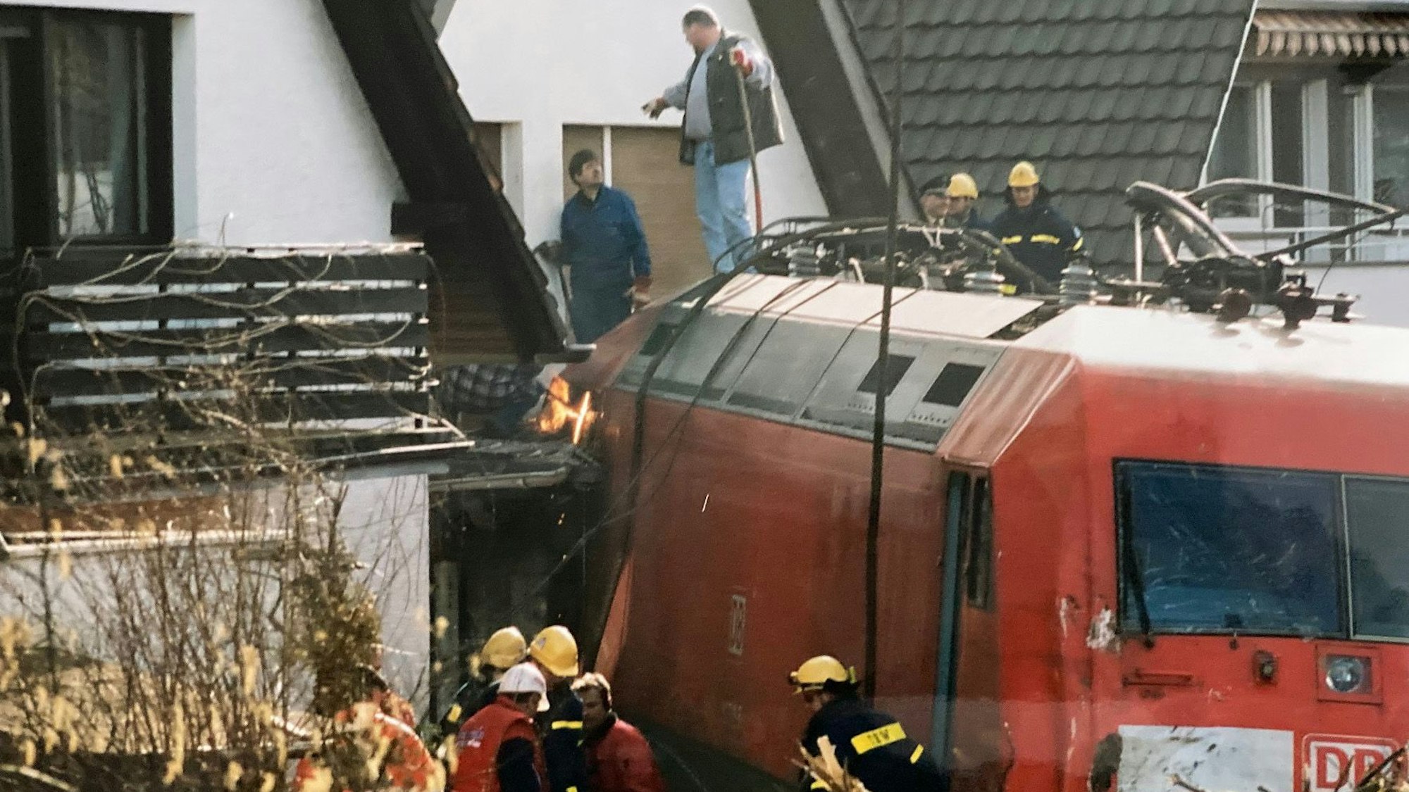 Auf dem Foto ist eine Lokomotive zu sehen. Zu beiden Seiten befinden sich Häuser.