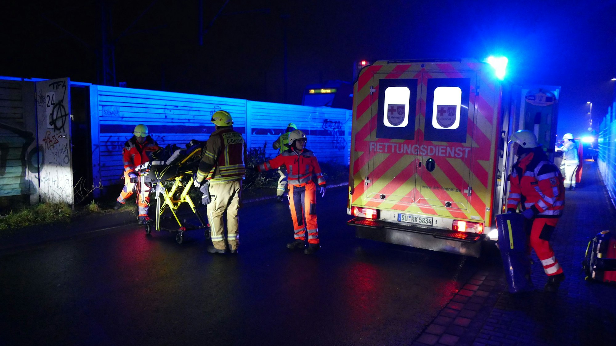 Feuerwehrleute stehen in der Industriestraße, wo der Zug zum Stehen gekommen ist.