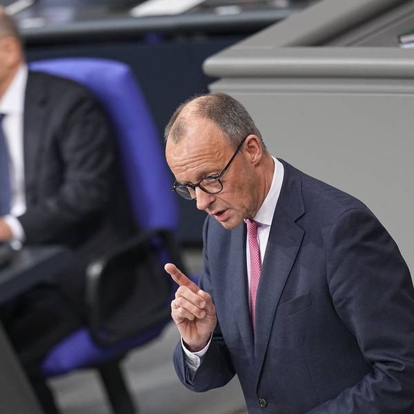 Bundeskanzler Olaf Scholz (SPD) hört Friedrich Merz (r), CDU Bundesvorsitzender und CDU/CSU Fraktionsvorsitzender im Bundestag, zu, als dieser bei der Debatte um das Zustrombegrenzungsgesetz im Plenarsaal im Bundestag spricht.
