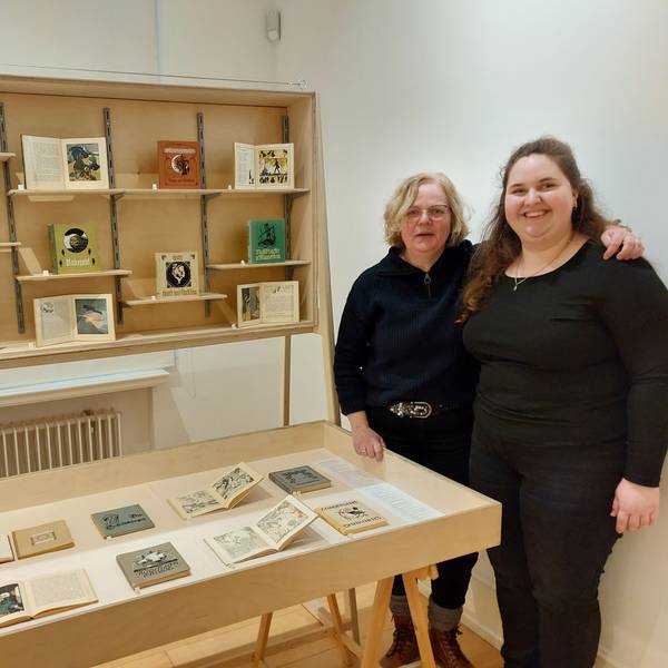 Zwei Frauen stehen neben Ausstellungsvitrinen in einem Museum.