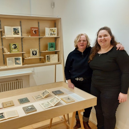 Zwei Frauen stehen neben Ausstellungsvitrinen in einem Museum.