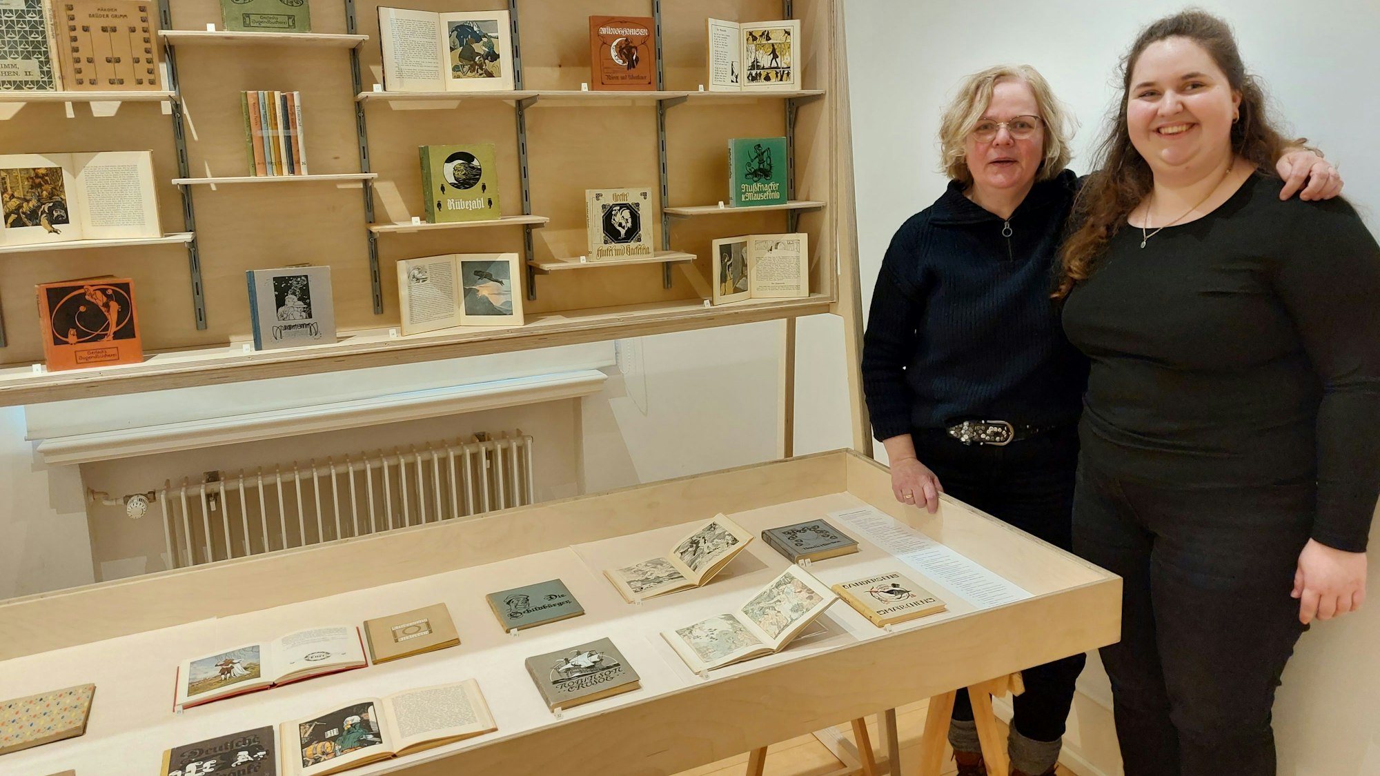 Zwei Frauen stehen in einem Raum, in dem Bilderbücher ausgestellt sind.