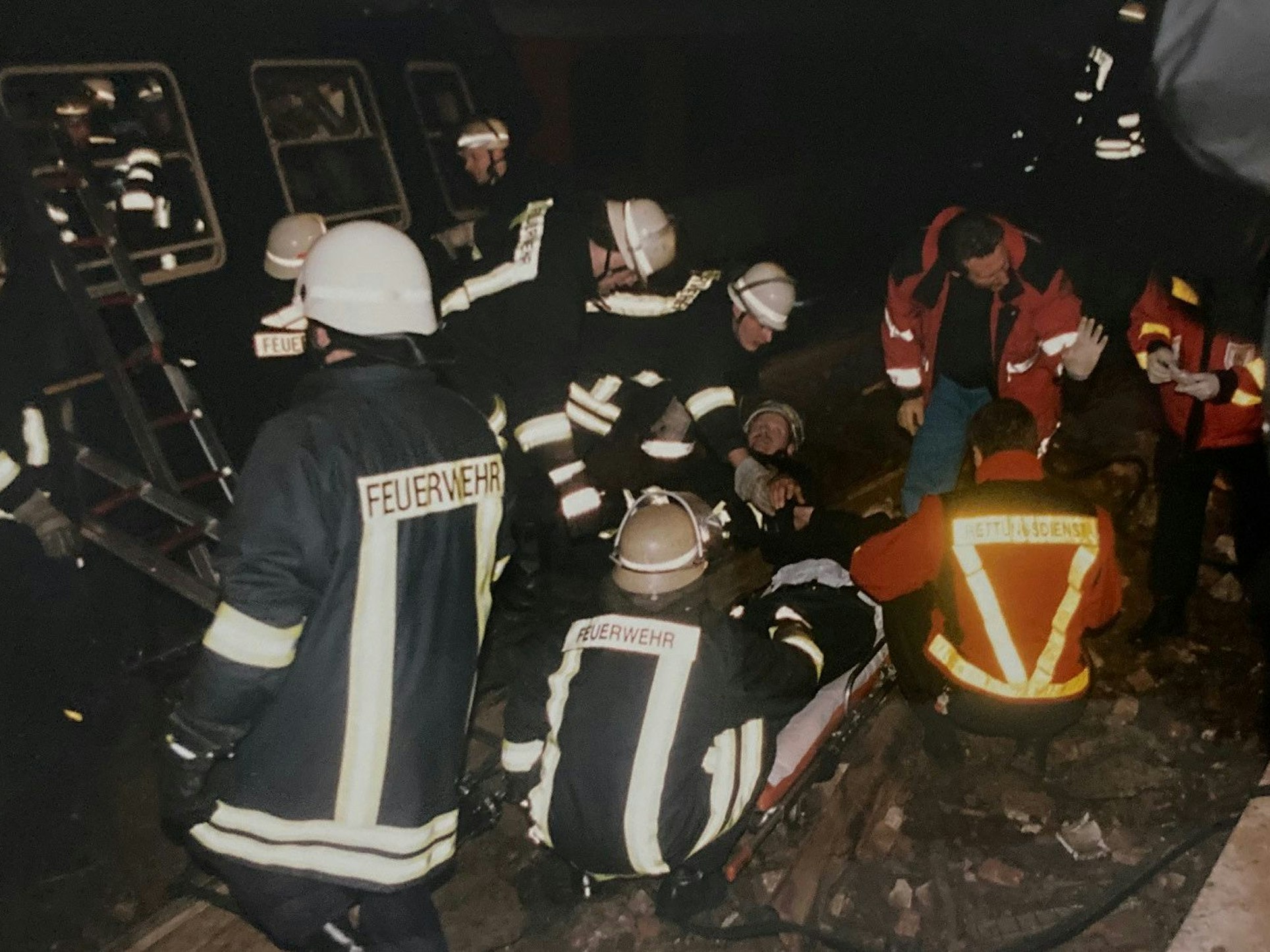 Das Bild zeigt Einsatzkräfte, die im Gleisbett einen Verletzten behandeln.