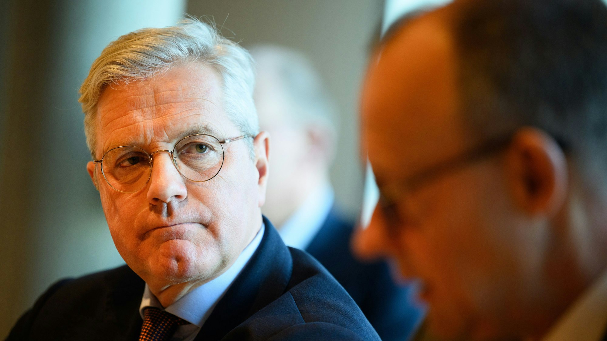 Norbert Röttgen (CDU) schaut Friedrich Merz bei einer gemeinsamen Veranstaltung von der Seite an. Friedrich Merz ist unscharf abgebildet.