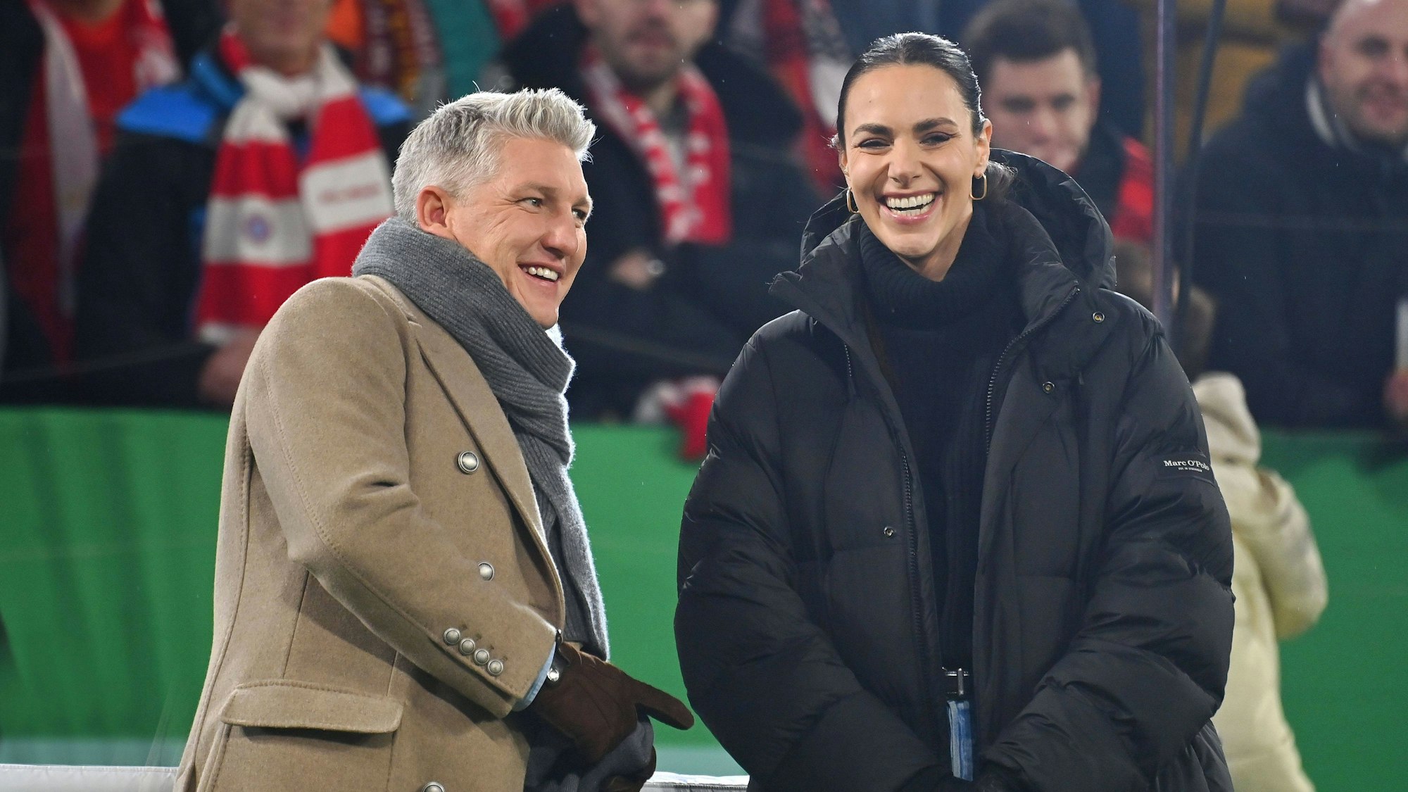 Bastian Schweinsteiger und Esther Sedlaczek stehen am Spielfeldrand.