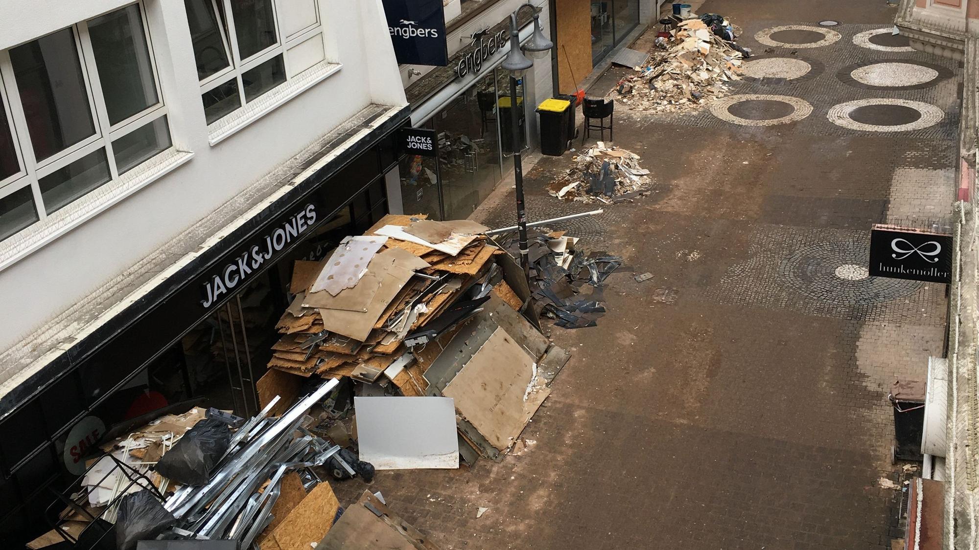 Vor den Ladenlokalen in der verschlammten Neustraße türmt sich der Sperrmüll.