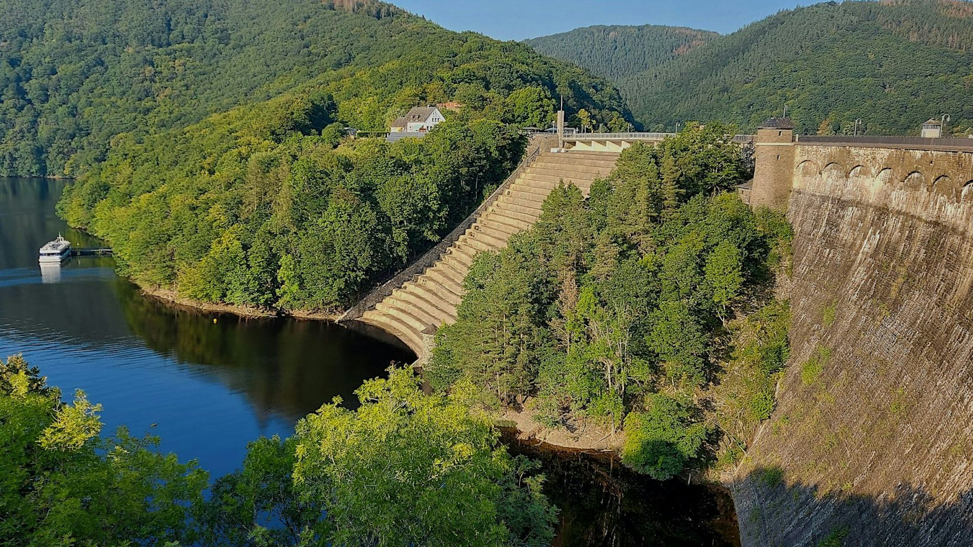 Die Staumauer des Urftsees ist von Bäumen umgeben.