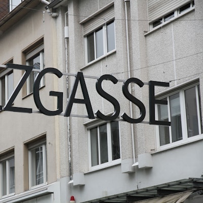 Ein Schriftzug aus metallenen Großbuchstaben über einer Einkaufsstraße.