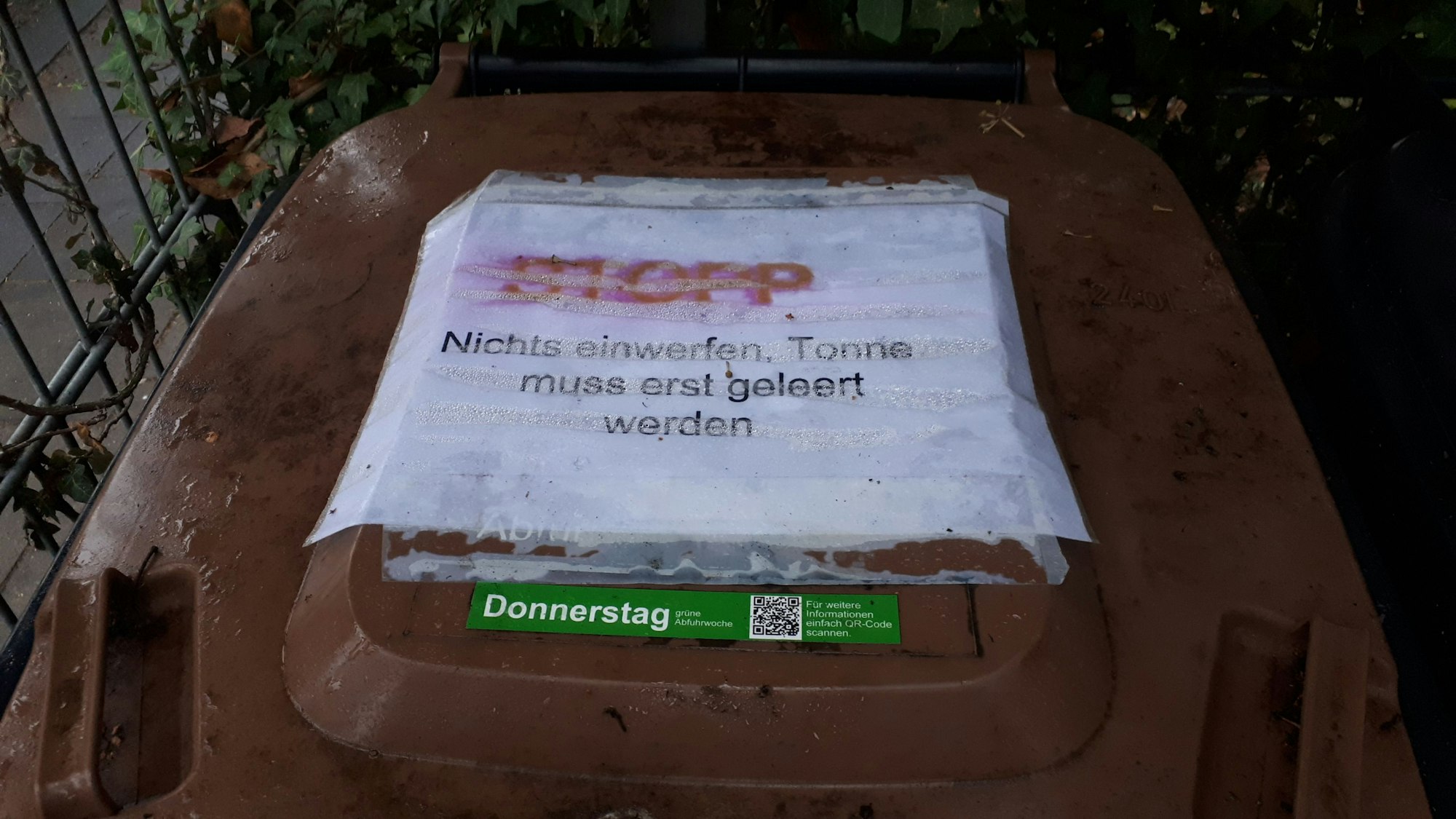 Auf dem Deckel einer Biotonne steht Stop Nichts einwerfen, Tonne muss erst geleert werden.