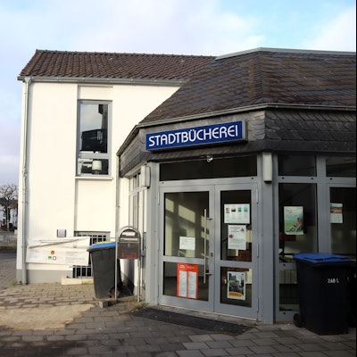 Außenansicht des Eingangs zur Stadtbücherei. Im Hintergrund ist der Bahnhof zu erkennen.