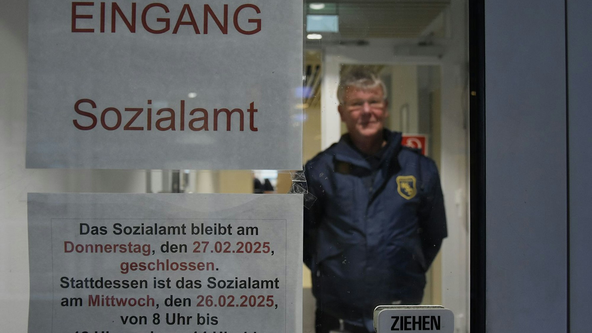 Das Foto zeigt einen Mitarbeiter eines Sicherheitsdienstes an der Tür des Sozialamtes.