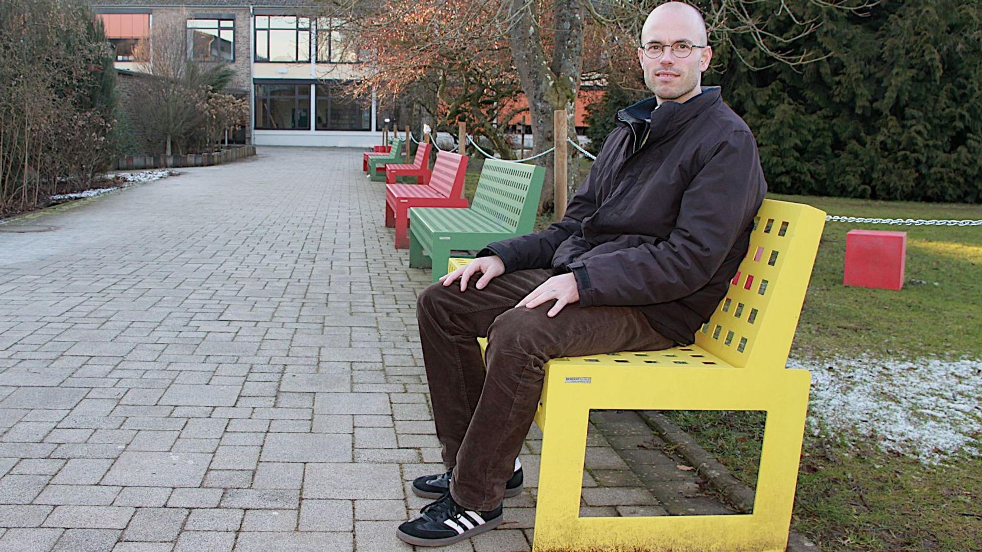 Pater Philipp Sauter sitzt auf einer Pausenbank.
