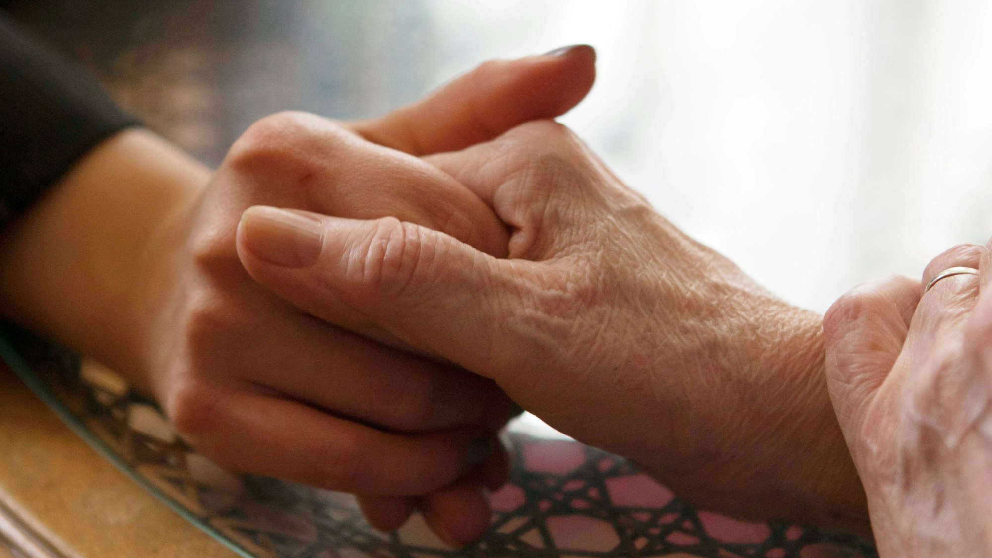 Zwei Menschen halten sich an den Händen.