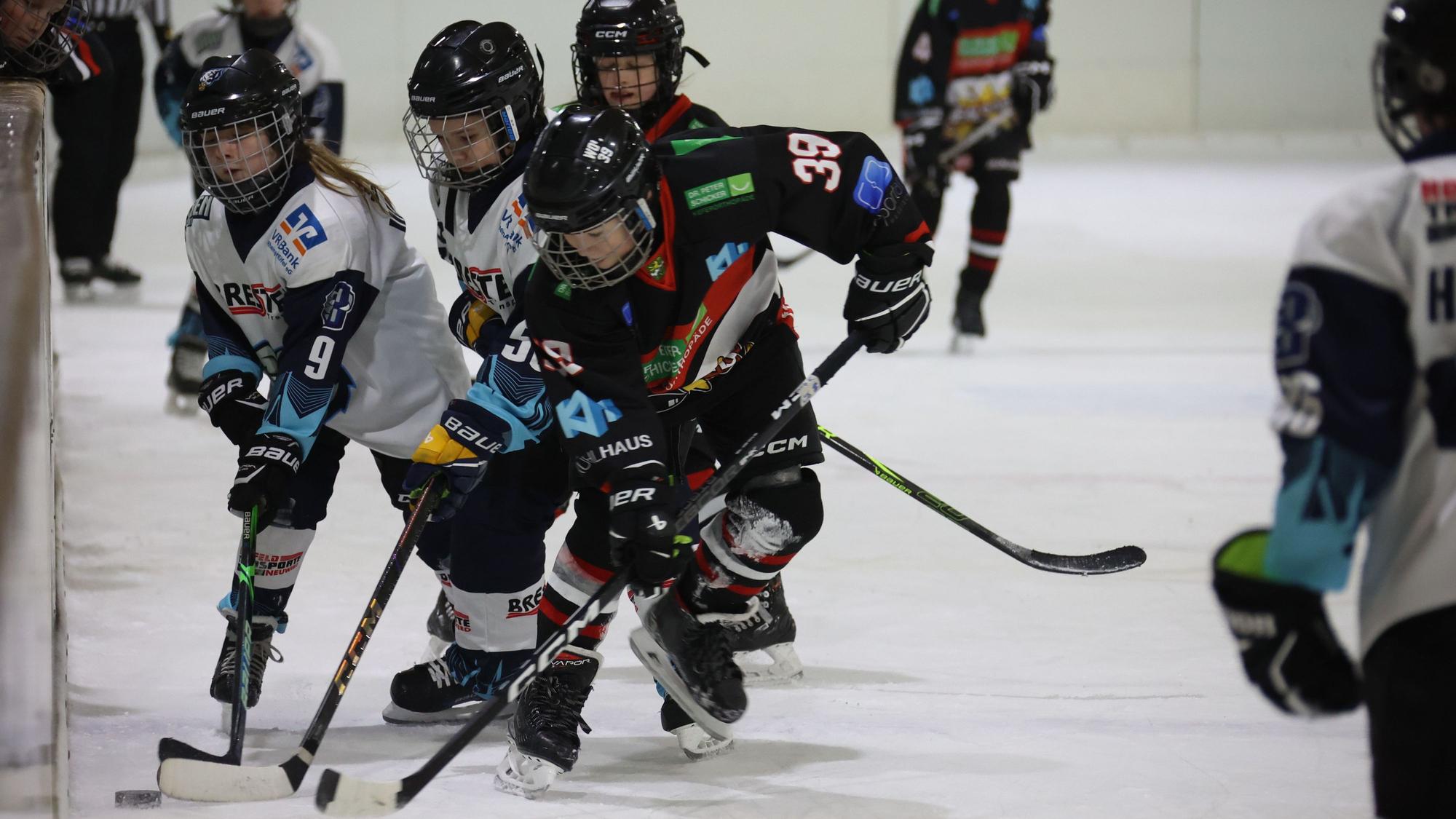 Der Eishockey-Spieler mit der 39 ist vor seinen Gegenspielern am Puck.