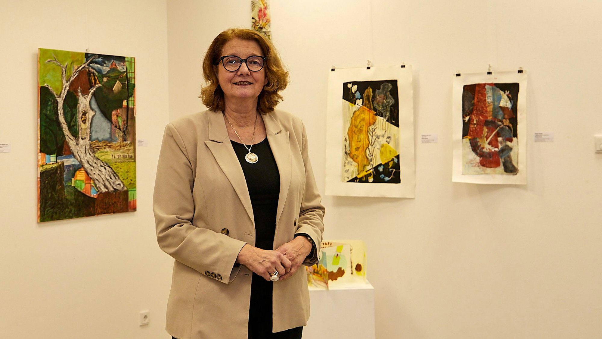 Das Bild zeigt Luzia Schlösser vor einigen Kunstwerken in der Kunstakademie.