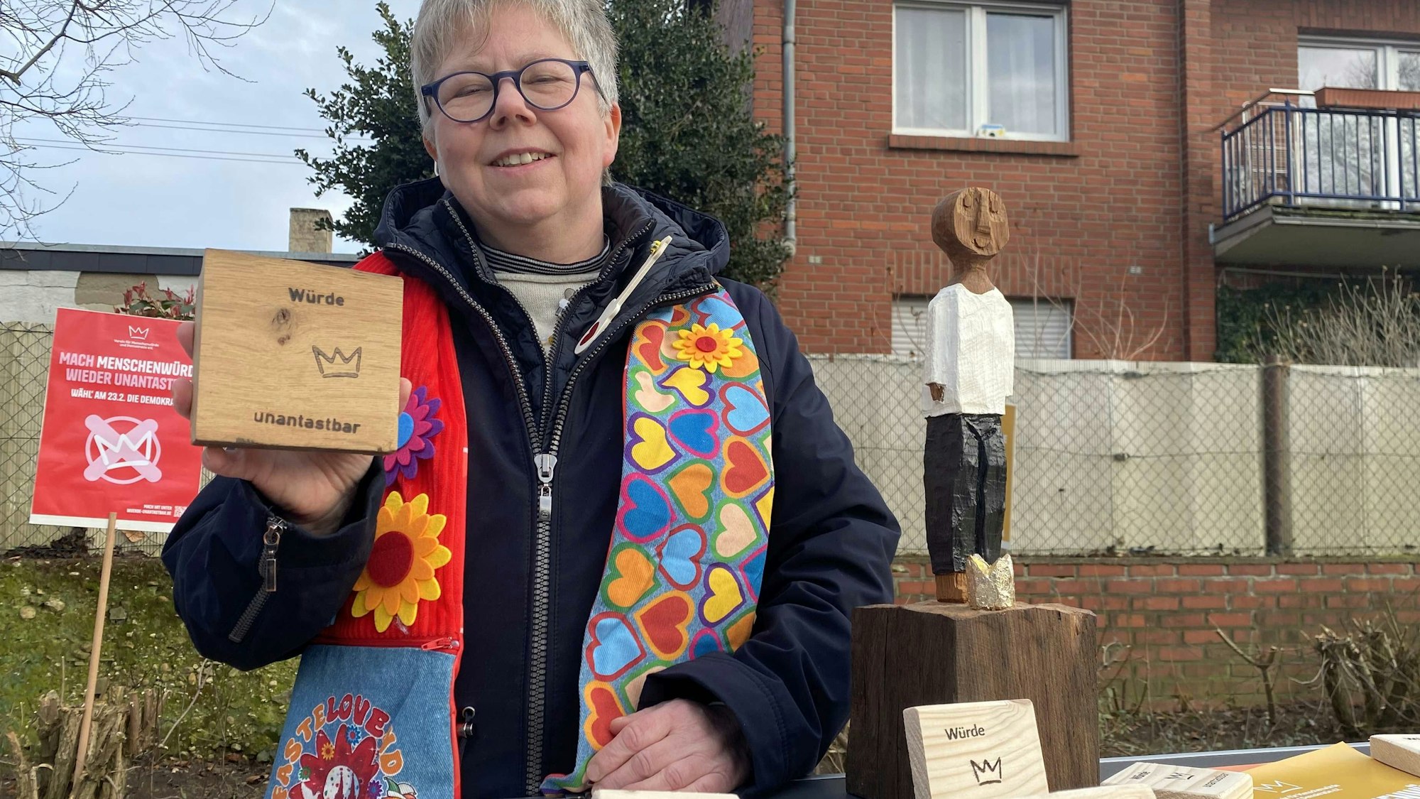 „Die Würde eines Menschen ist unantastbar“: Die Heimerzheimerin Christine Luppus vom Netzwerk für Menschenwürde und Demokratie hatte Holztäfelchen im Gepäck und war Gastrednerin auf der Demo.
