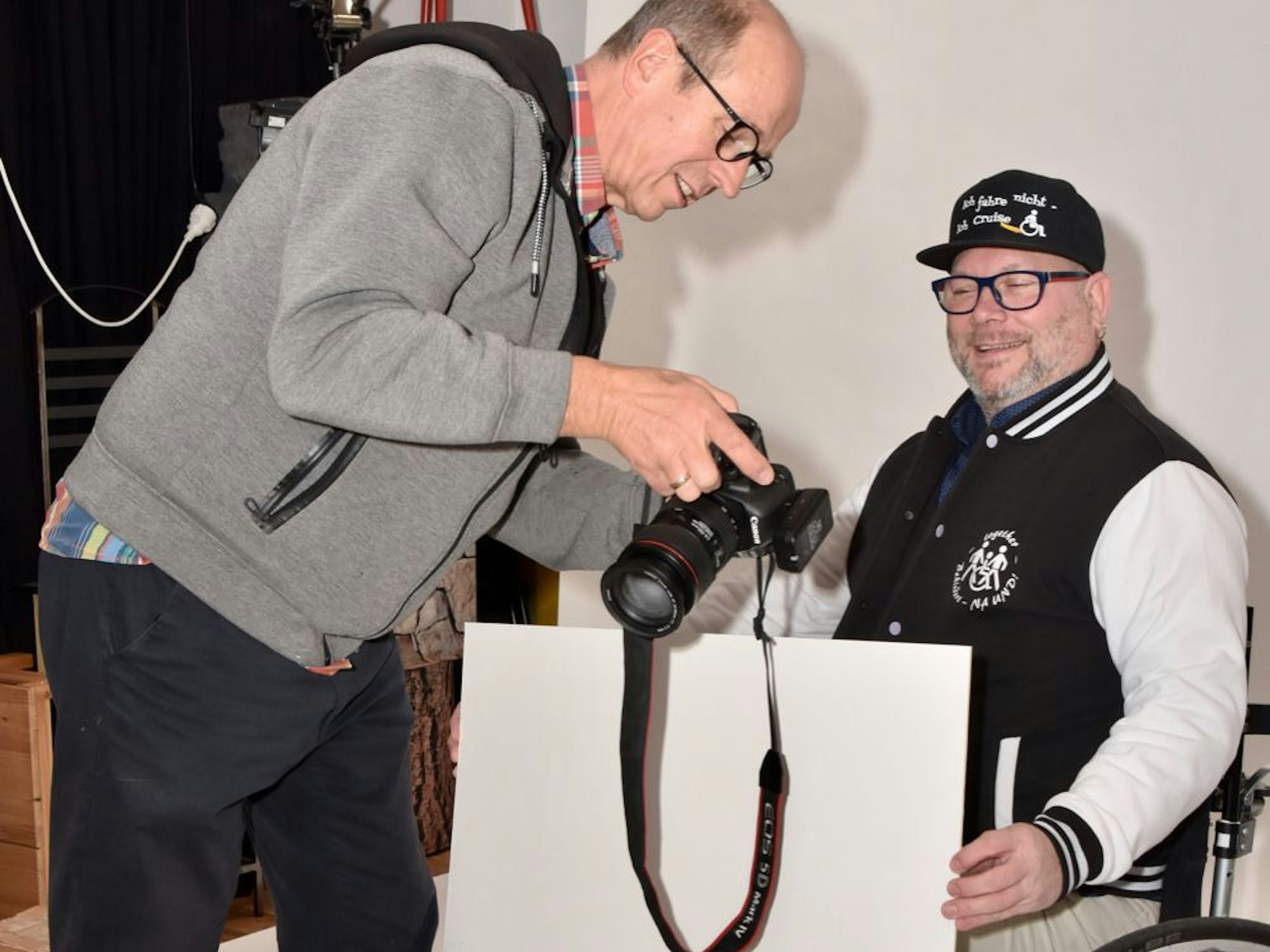 Der Fotograf zeigt einem porträtierten Karnevalisten die Fotos auf dem Kamera-Display.