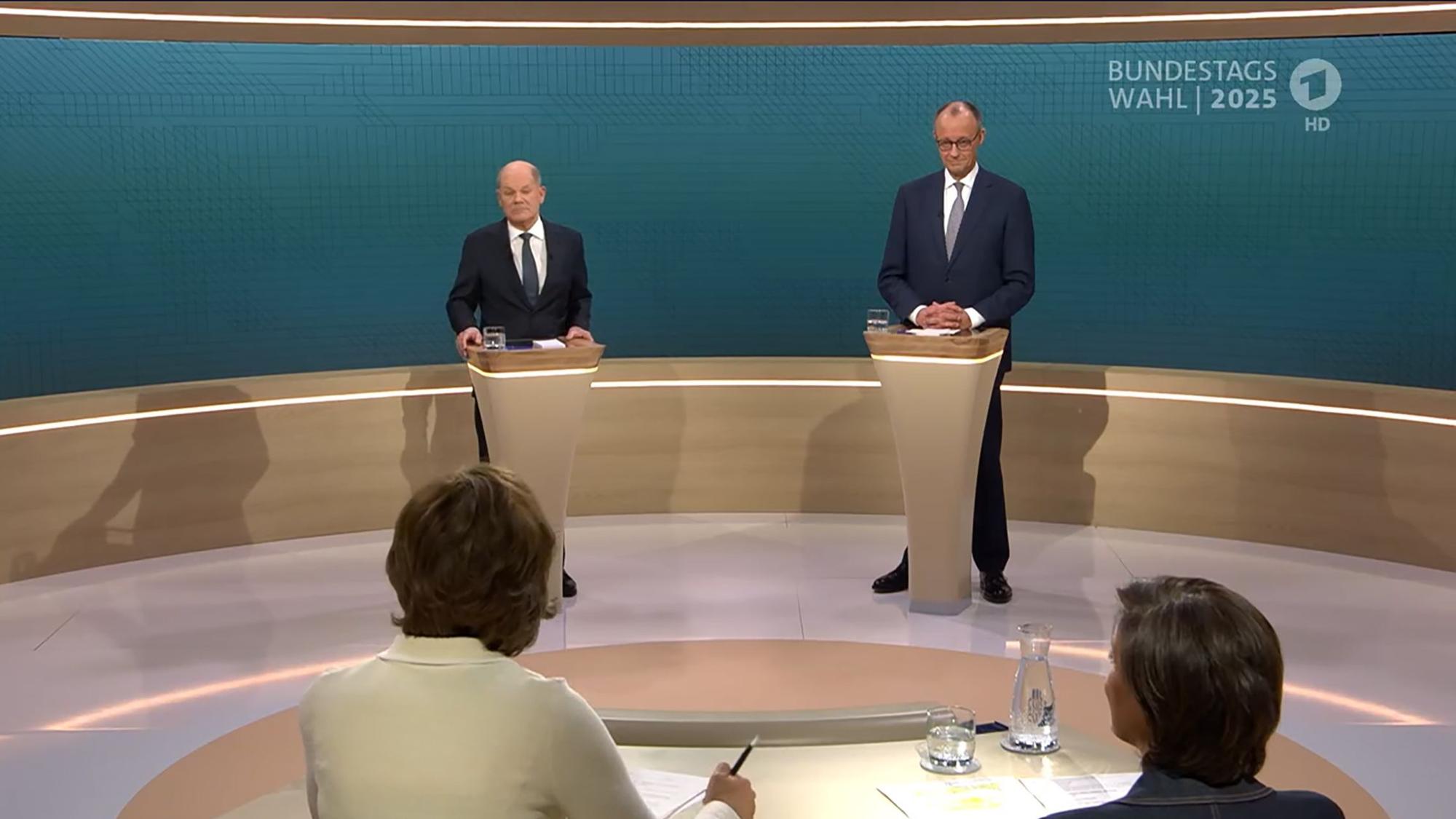 SCREENSHOT - 09.02.2025, Berlin: Bundeskanzler Olaf Scholz (SPD, l), steht neben Friedrich Merz, Unions Kanzlerkandidat und CDU Bundesvorsitzender, während dem TV-Duell von ARD und ZDF (Screenshot). In 90 Minuten stellen sich beide im Studio Berlin-Adlershof zentralen Fragen und debattieren zu den wesentlichen Themen des Bundestagswahlkampfs. Moderiert wird die Sendung von Sandra Maischberger (unten r, ARD) und Maybrit Illner (unten l, ZDF). Foto: ---/ARD/ZDF/dpa - ACHTUNG: Nur zur redaktionellen Verwendung im Zusammenhang mit einer Berichterstattung über die Sendung TV Duell 2025 und nur mit vollständiger Nennung des vorstehenden Credits +++ dpa-Bildfunk +++