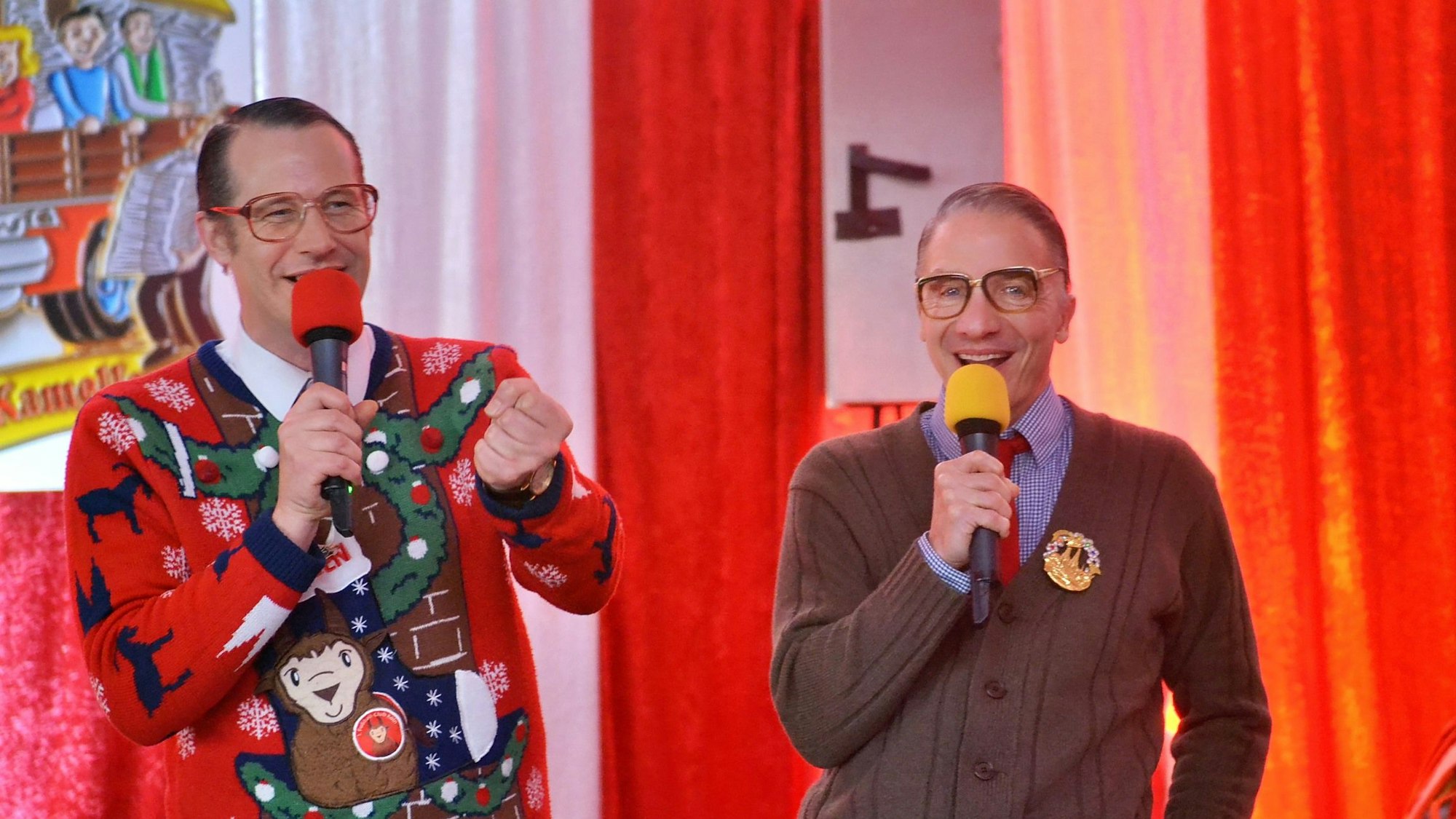 Das Duo Willi und Ernst steht mit Mikrofonen auf der Bühne.
