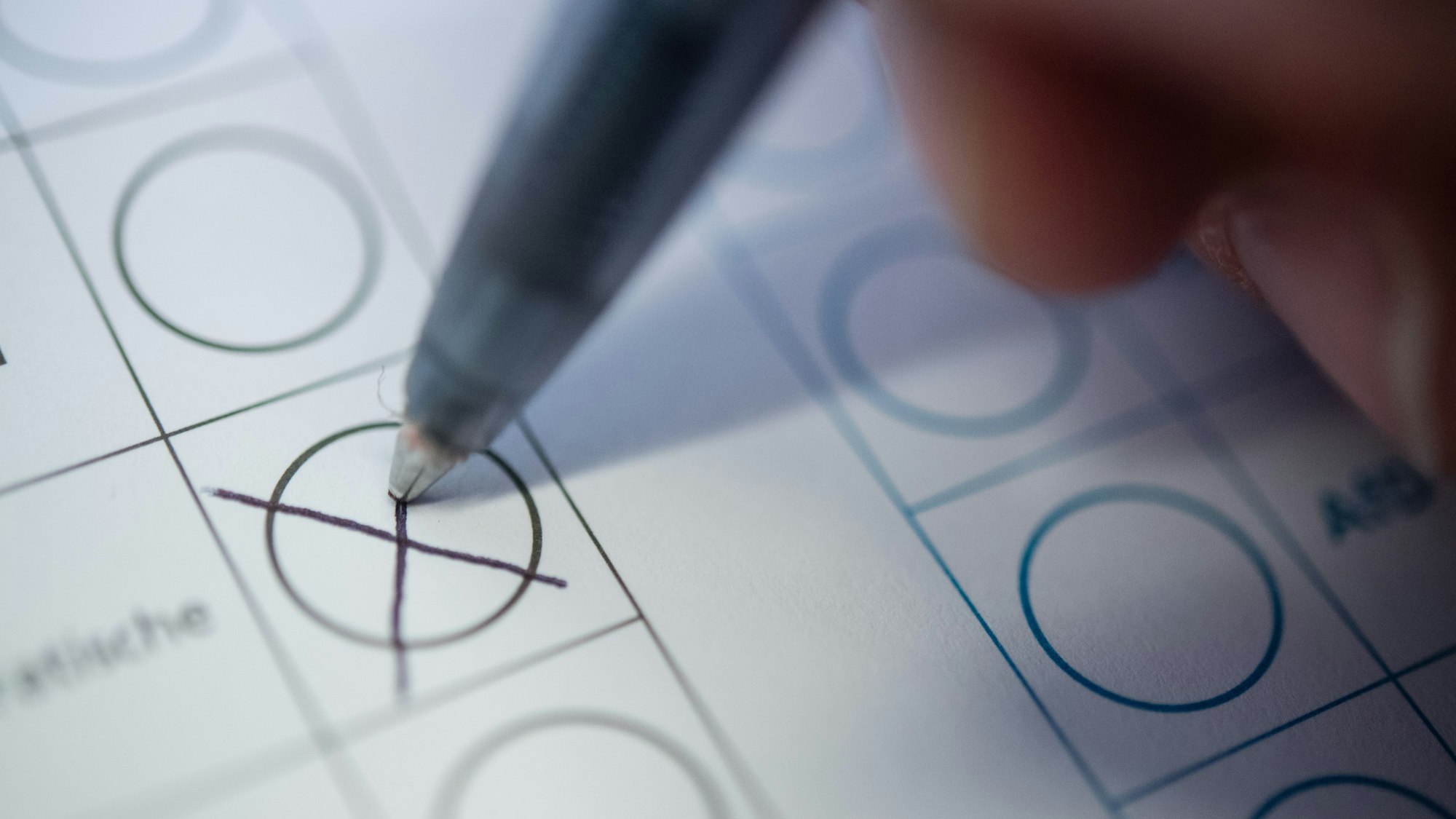 Eine Frau macht ein Kreuz auf einem Wahlzettel.