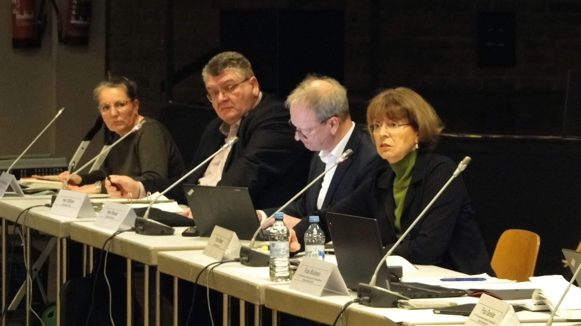 An einem langen Tisch sitzen mehrere Personen, darunter Kölns OB Henriette Reker.