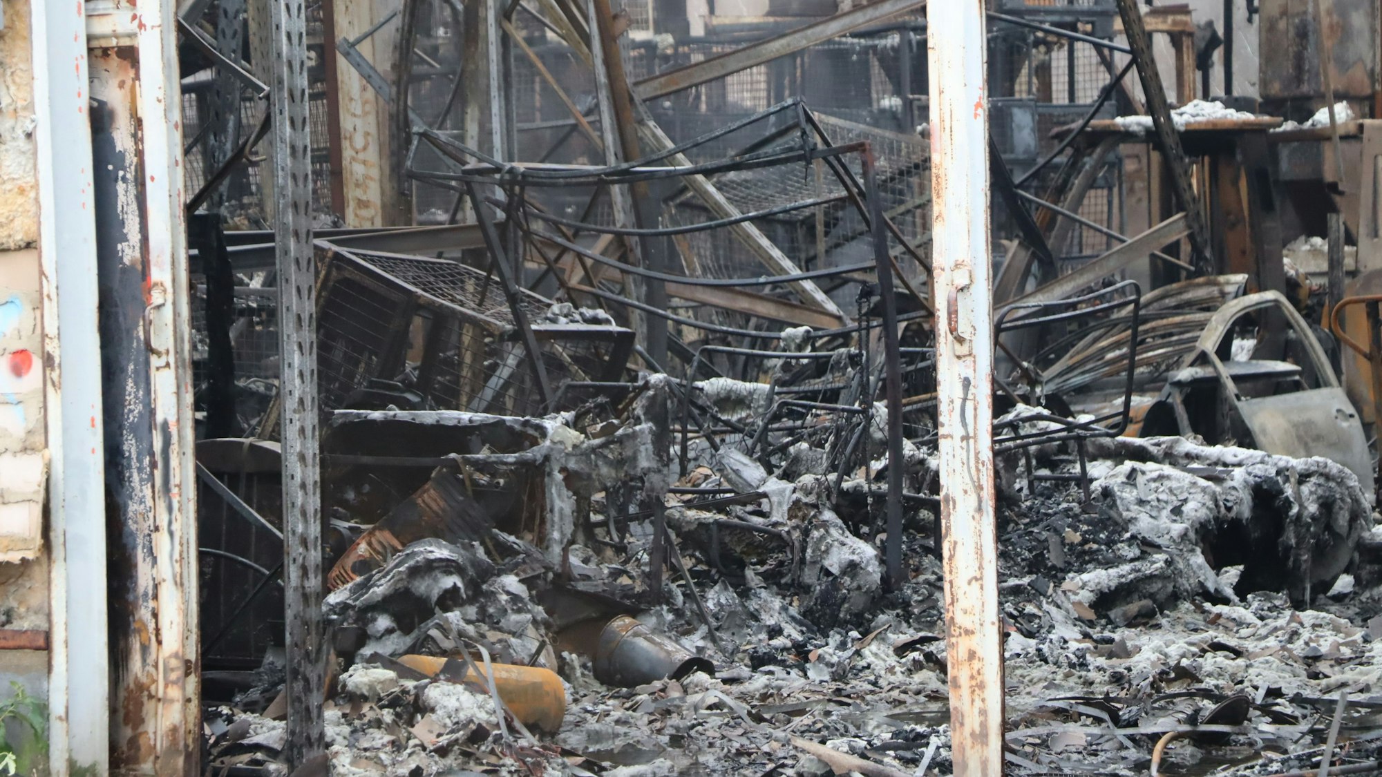 Fahrzeuge und Gebäudeteile sind bis zur Unkenntlichkeit verbrannt.