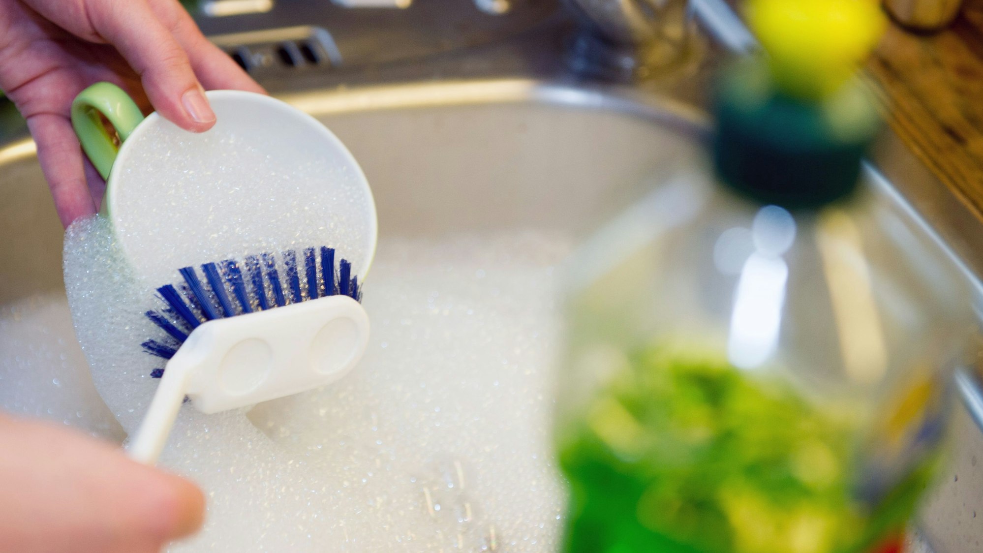 Eine Frau spült Geschirr.